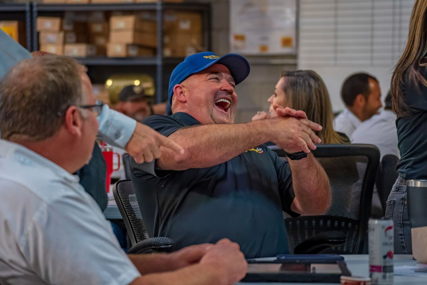 Animated conversation and laughter during a casual business meeting at a table.