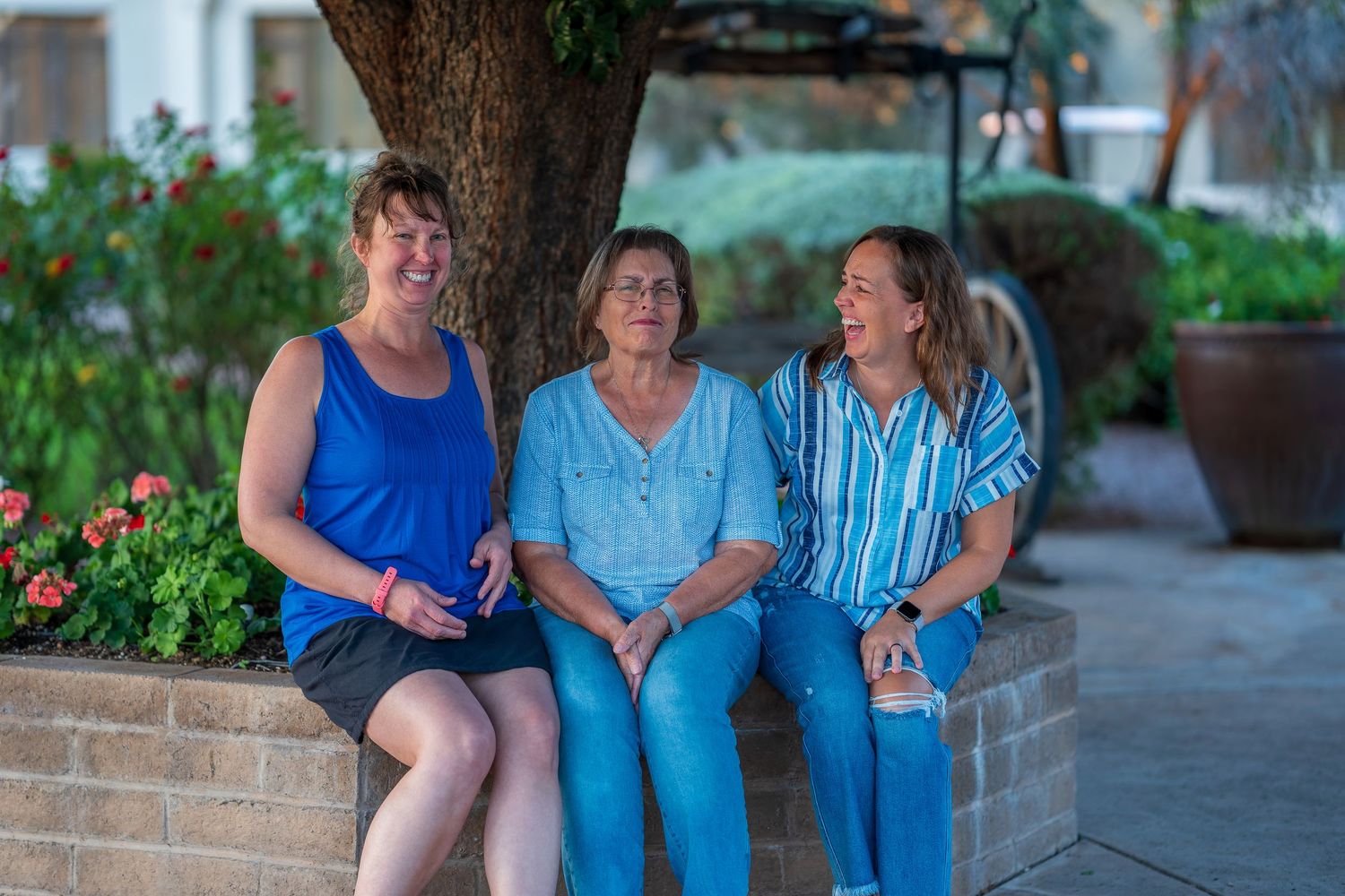 Family members share candid moments during an outdoor photo session at sunset.