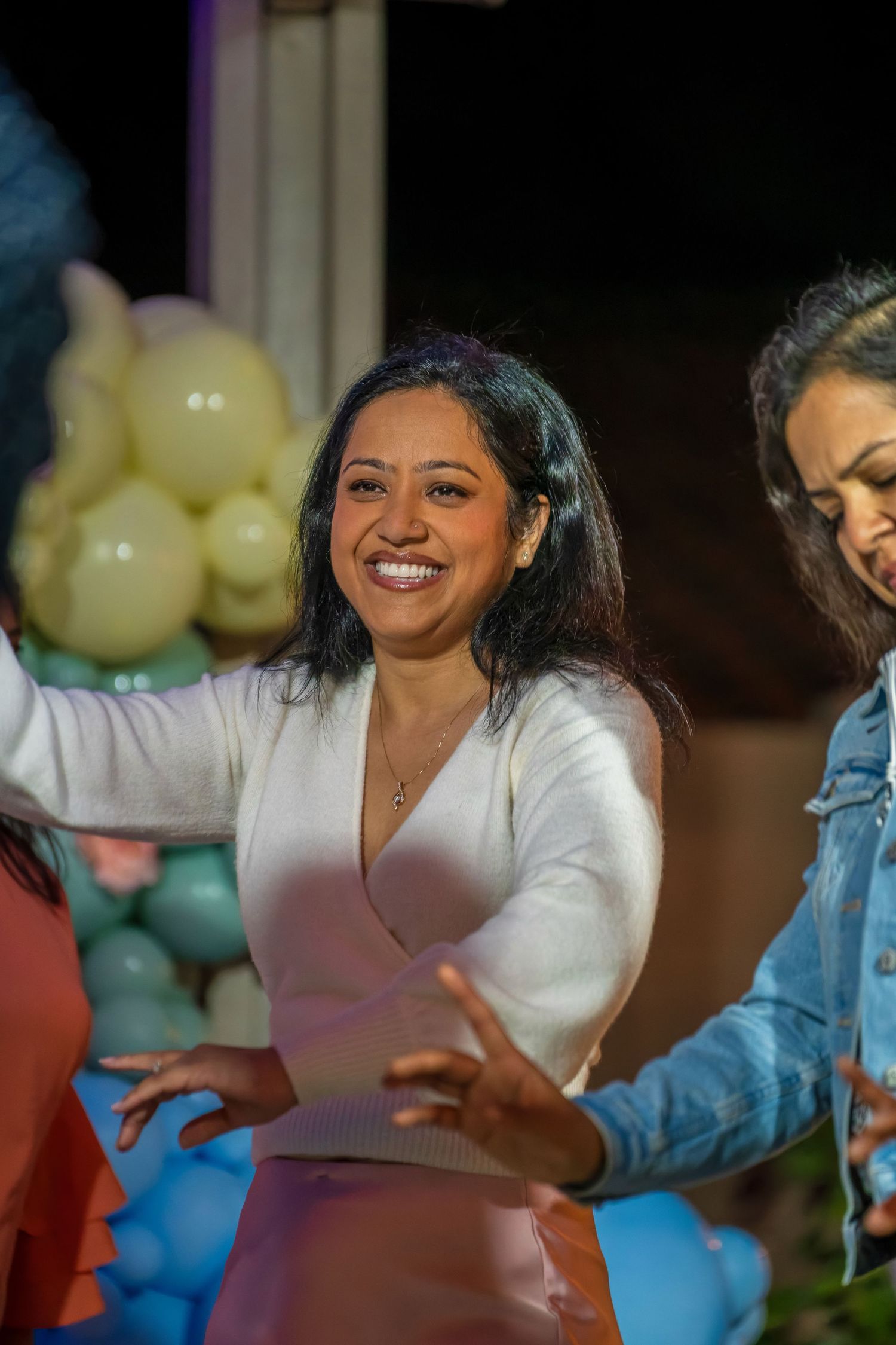 Energetic dance moves captured during a lively celebration with balloon decorations.