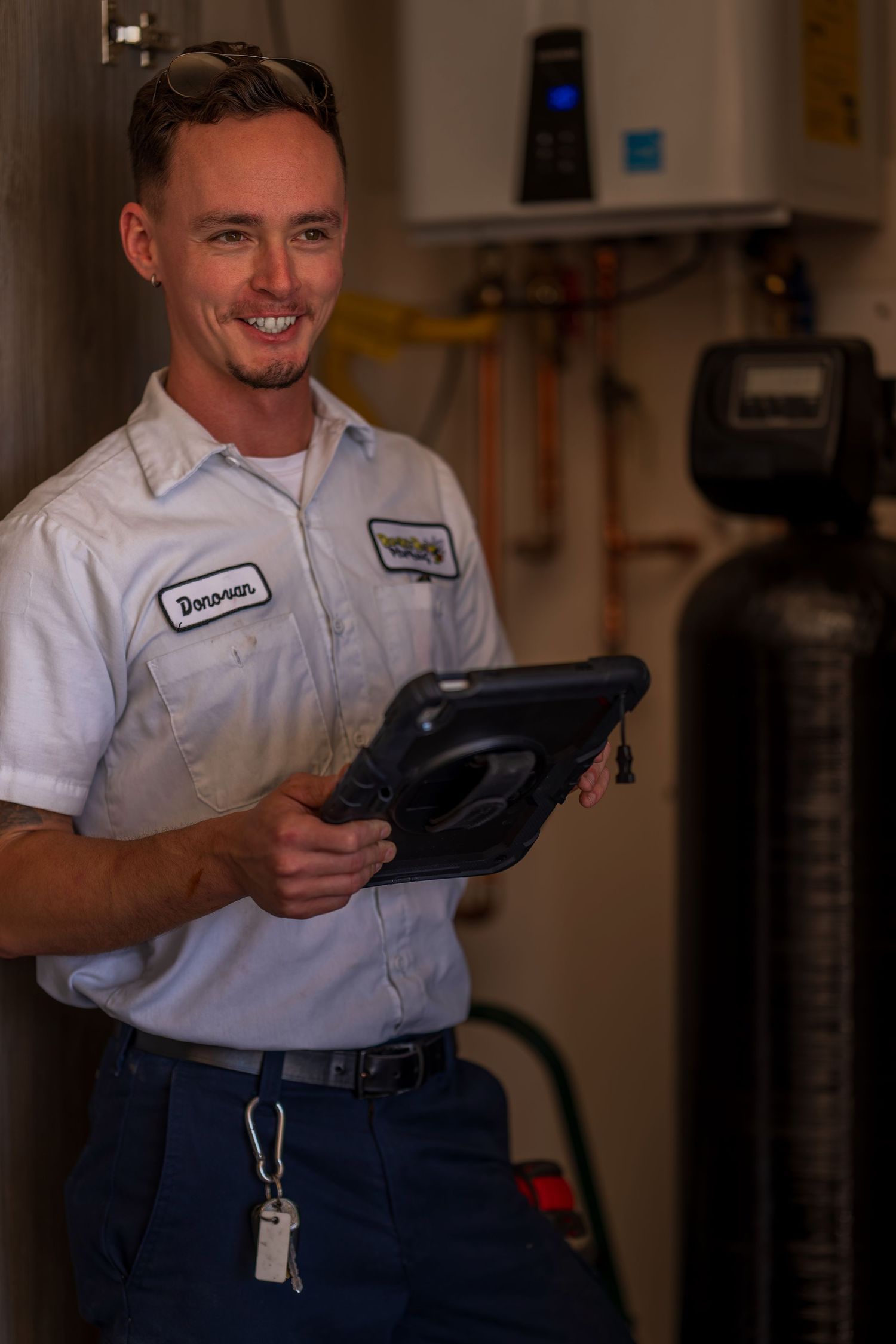 Service technician in uniform checking digital tablet indoors.