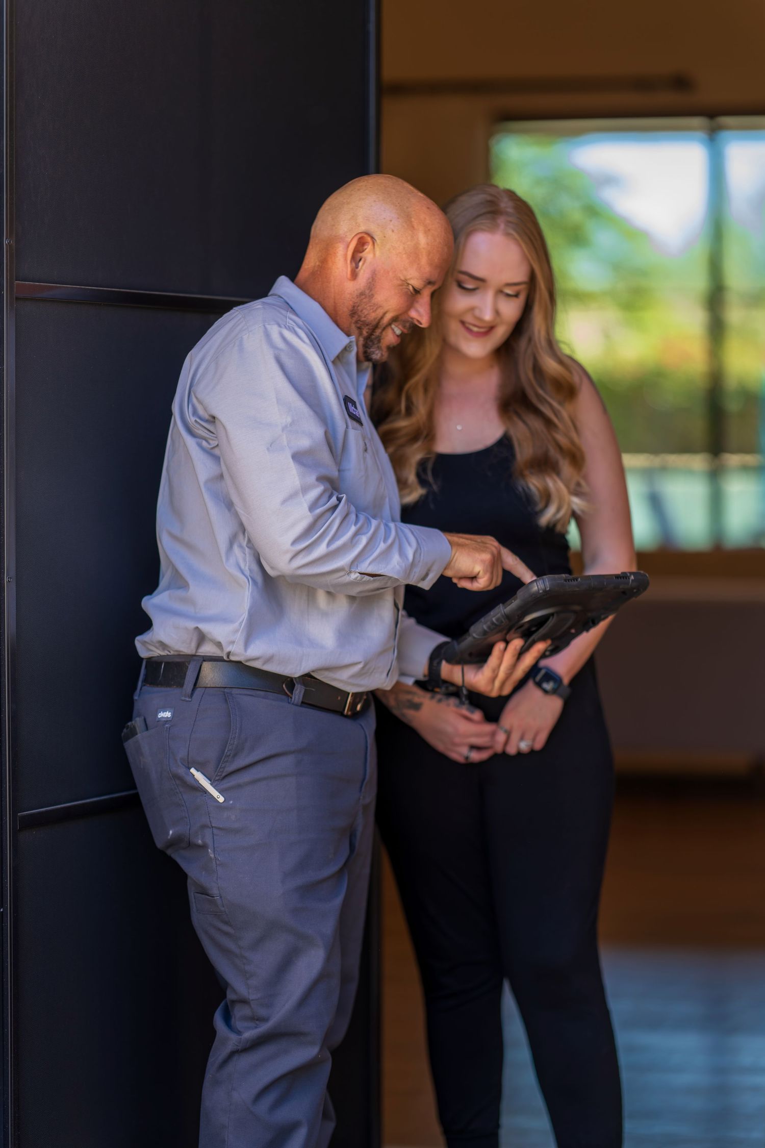 Service professional reviewing information on tablet device indoors.