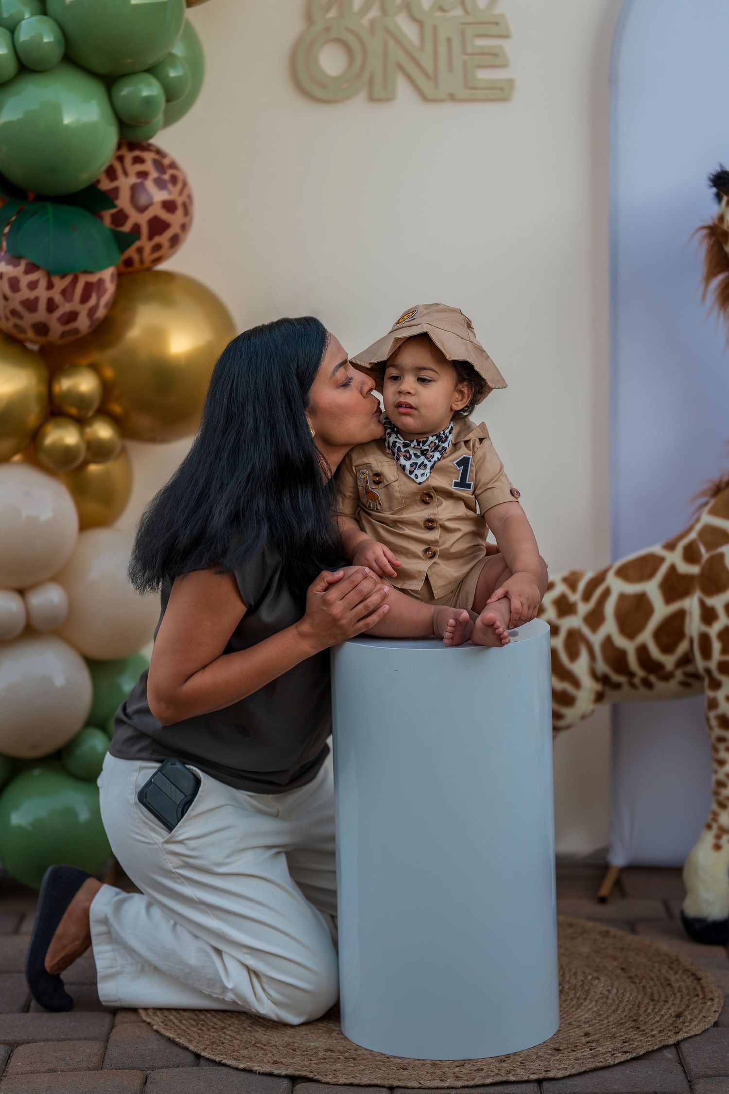 Festive first birthday celebration with safari-themed decorations and gold balloons.
