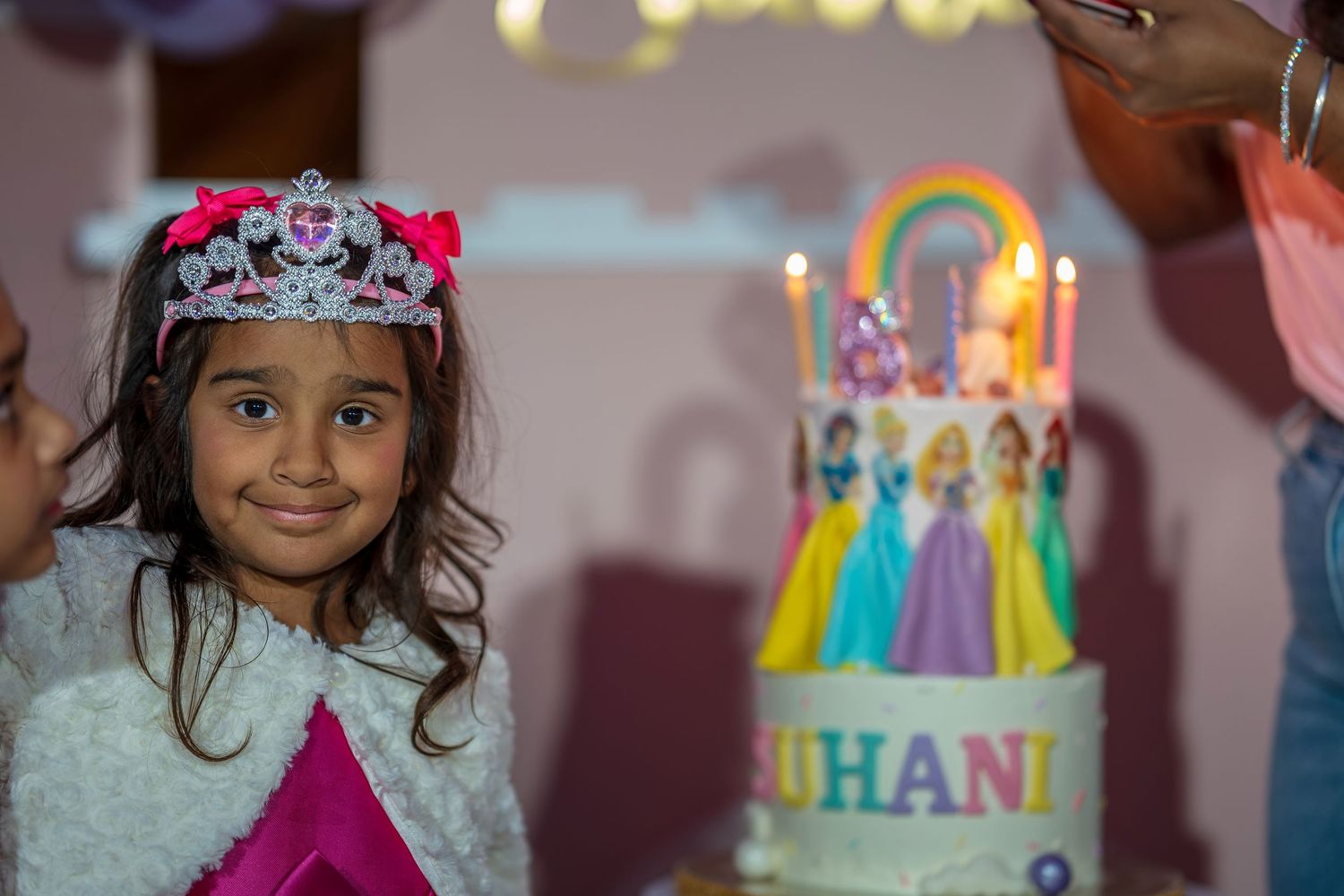 A festive birthday scene with a decorated cake featuring rainbow colors and tassels.