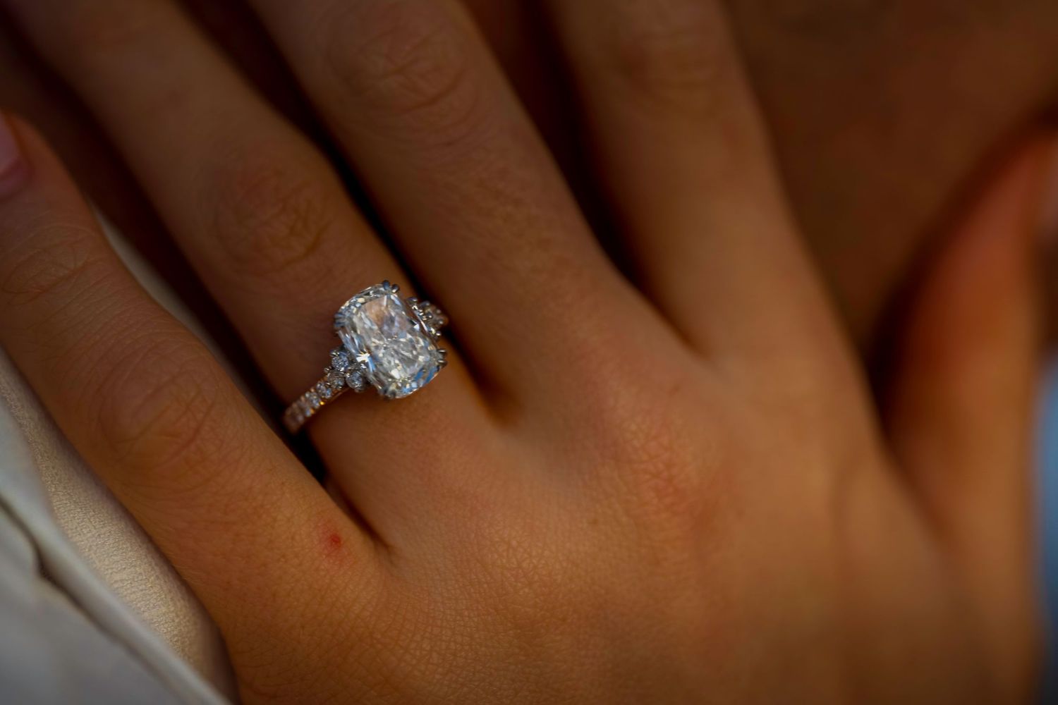Detailed view of hands with a diamond engagement ring.