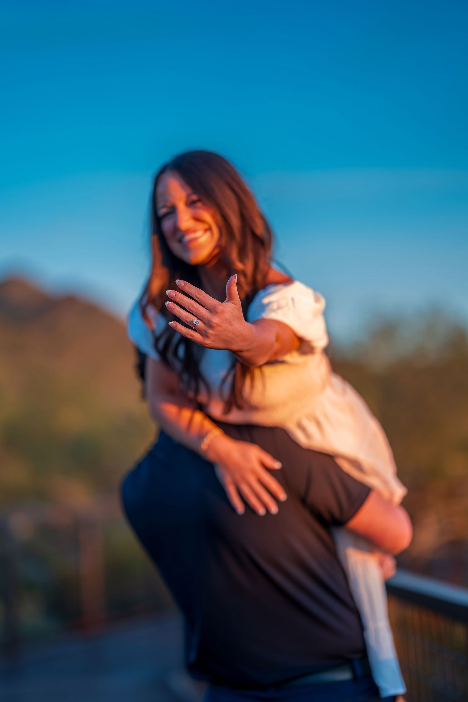Couple embracing and laughing together during a golden hour photo session.