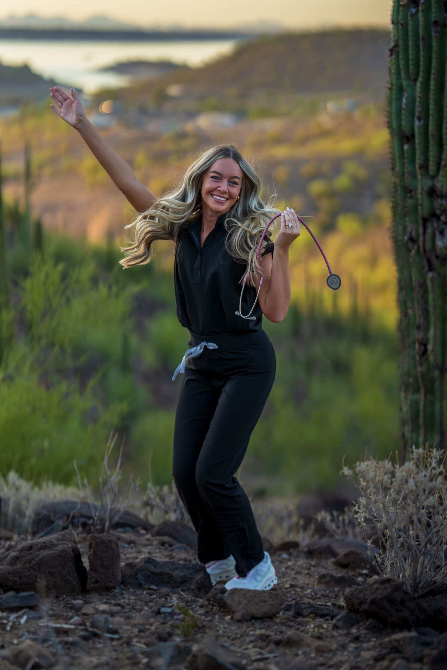 Candid moment of healthcare worker dancing in desert setting with mountains in background.