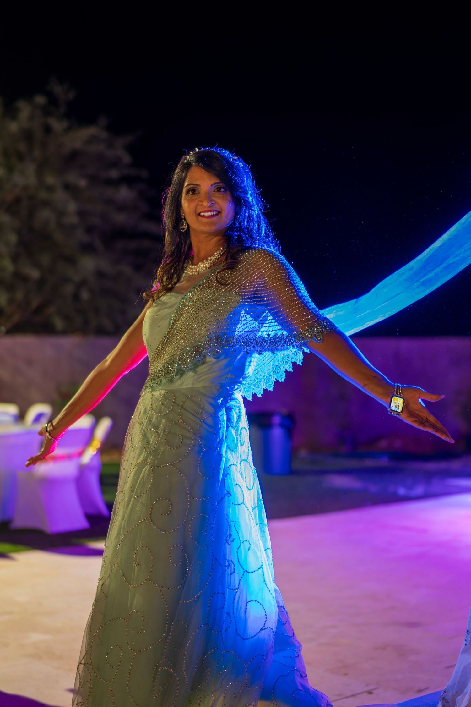 Night portrait with dramatic blue lighting of person in white lace dress.