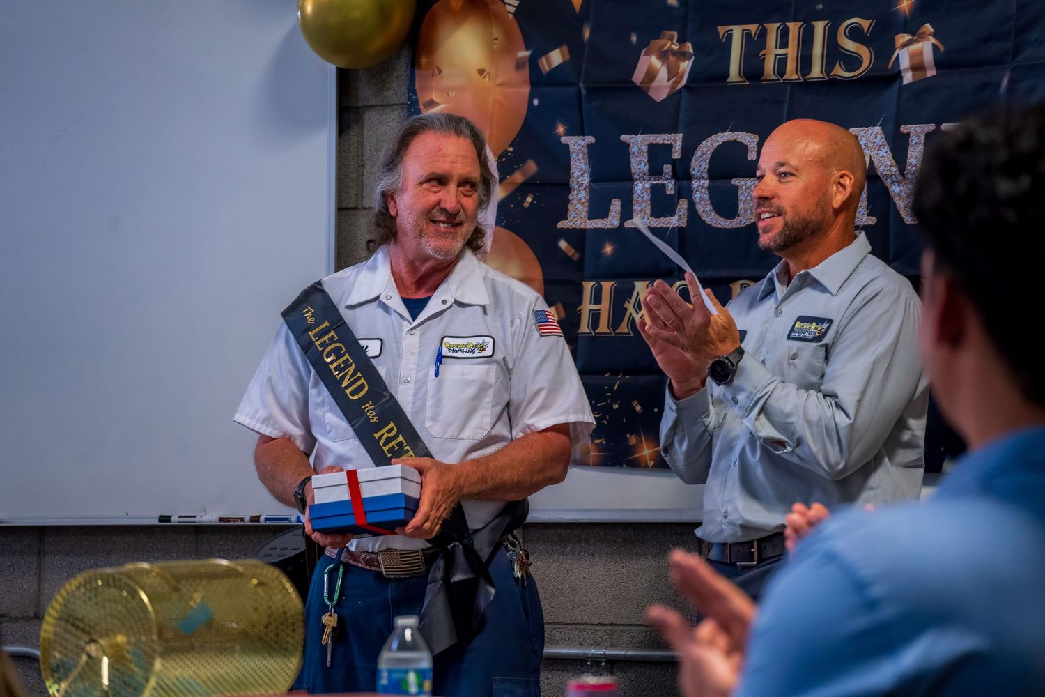 Two employees celebrating with awards at a company recognition event.