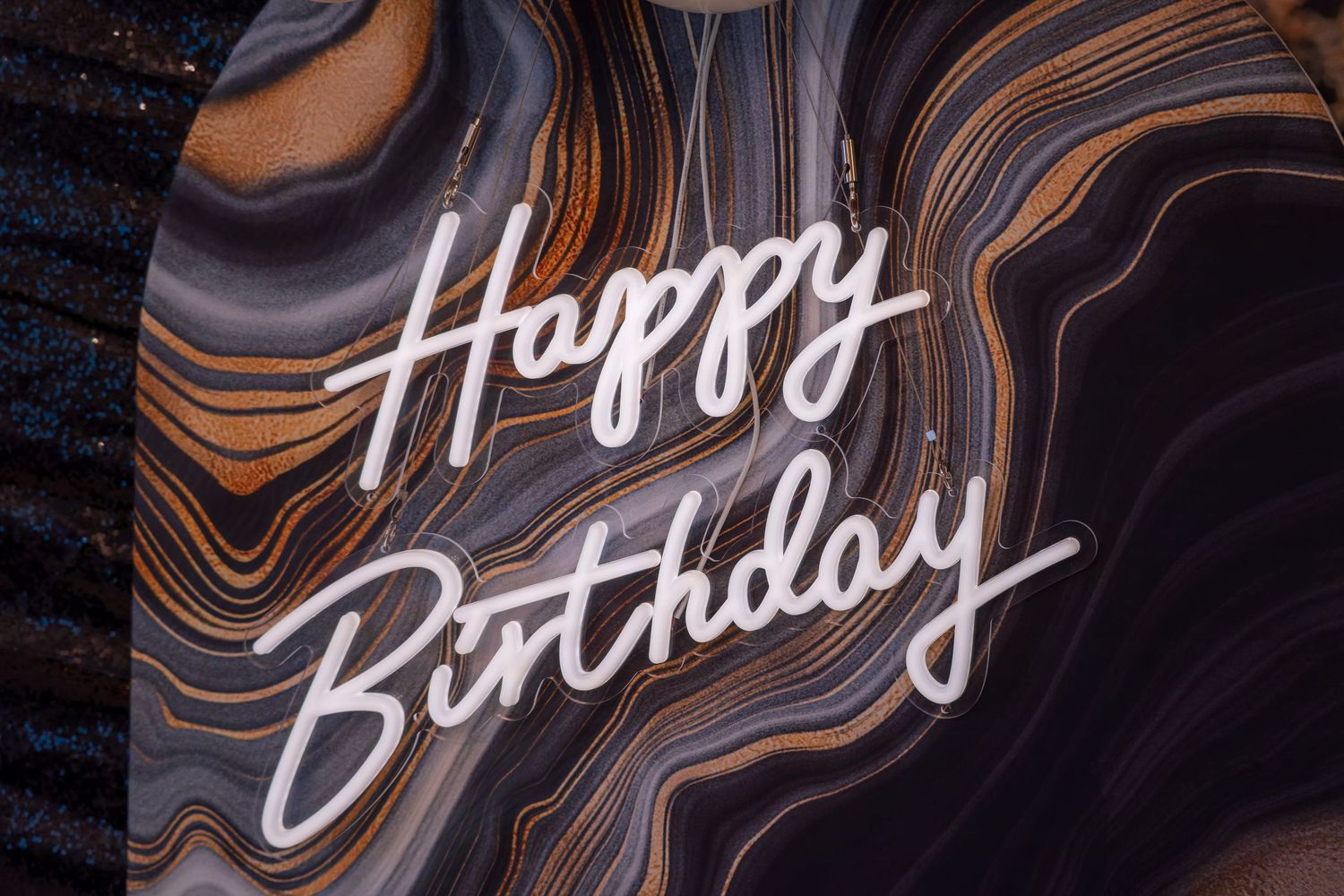 Happy Birthday text written in white script against a swirling dark marble pattern background.