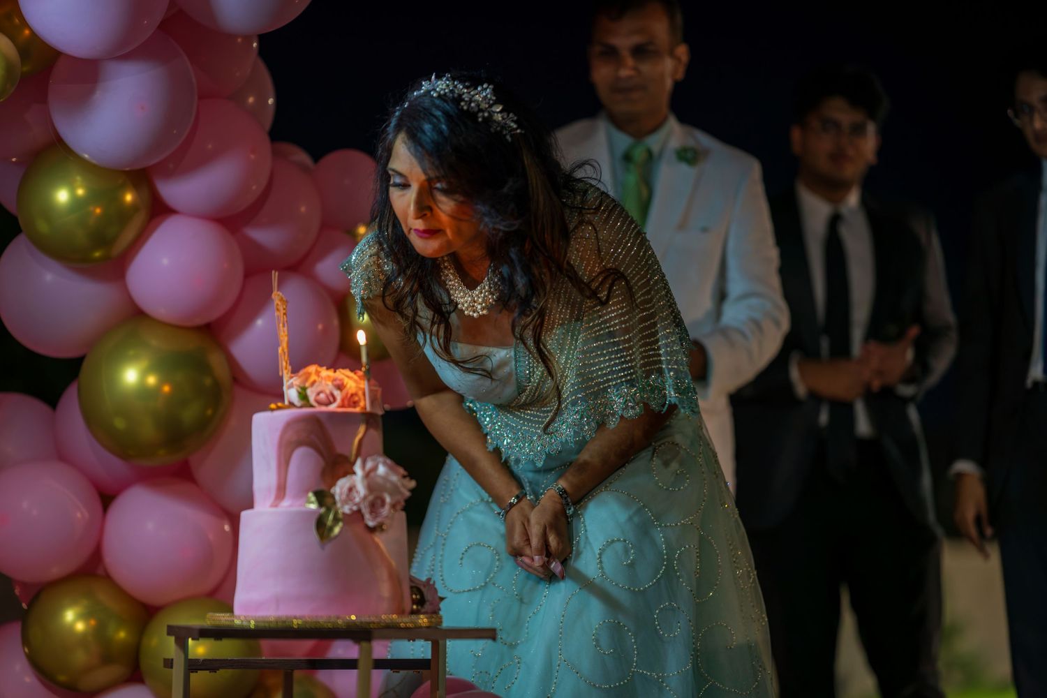 A festive party scene with pink and gold balloon decorations.