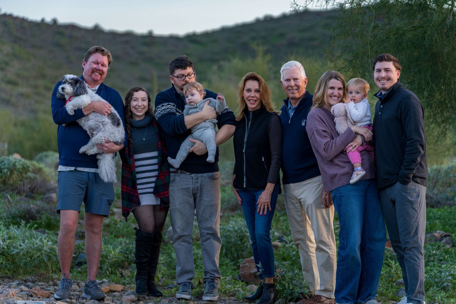 A group photo taken at dusk with natural desert landscape in the background.