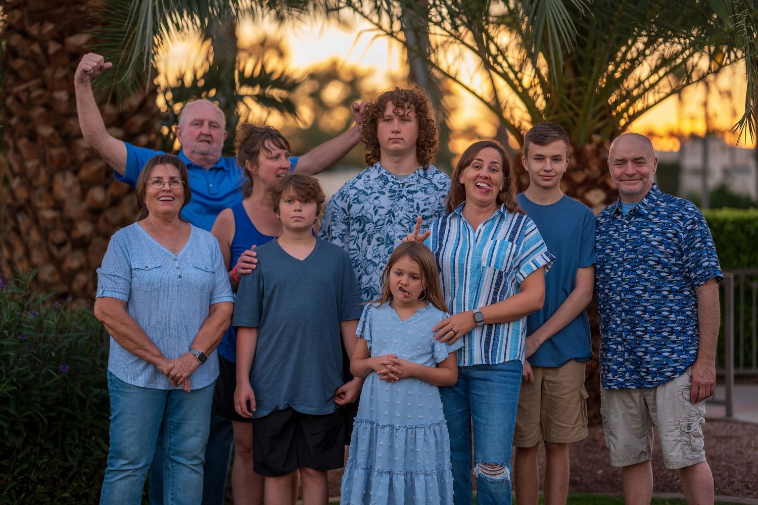 Extended family gathering outdoors during golden hour with palm trees.