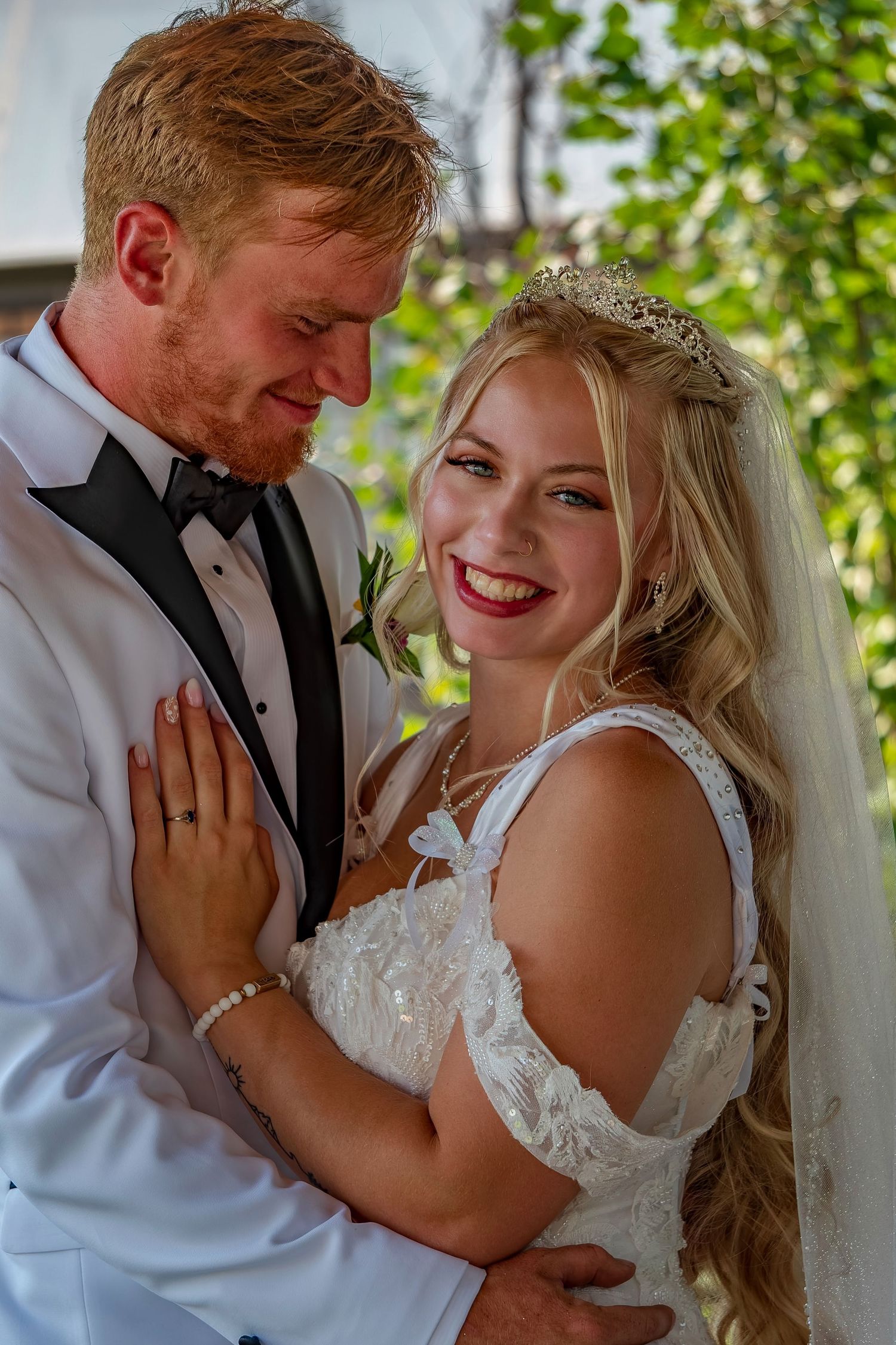 Romantic wedding portrait showing tender moment between newlyweds in garden setting.