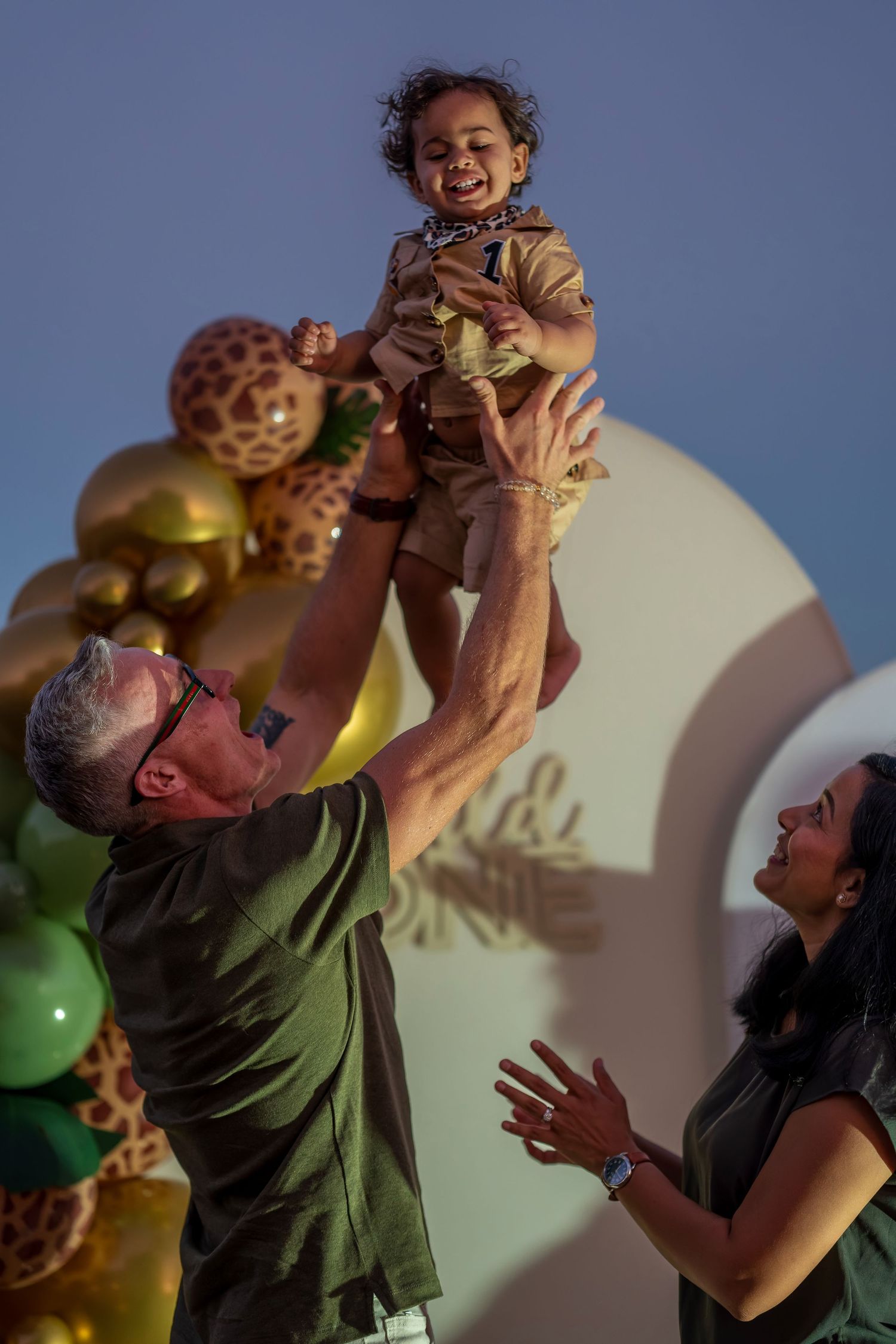 Happy celebration with safari-themed party decorations and gold balloon arrangements.