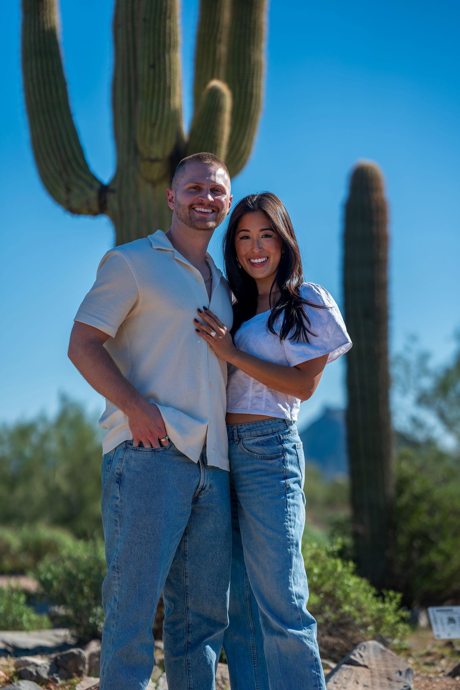 Candid desert photoshoot featuring people in matching white tops and blue jeans.