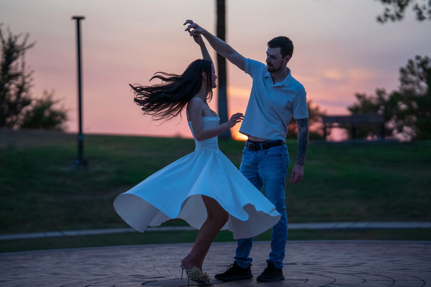 Silhouettes of dancers performing against a vibrant sunset backdrop.