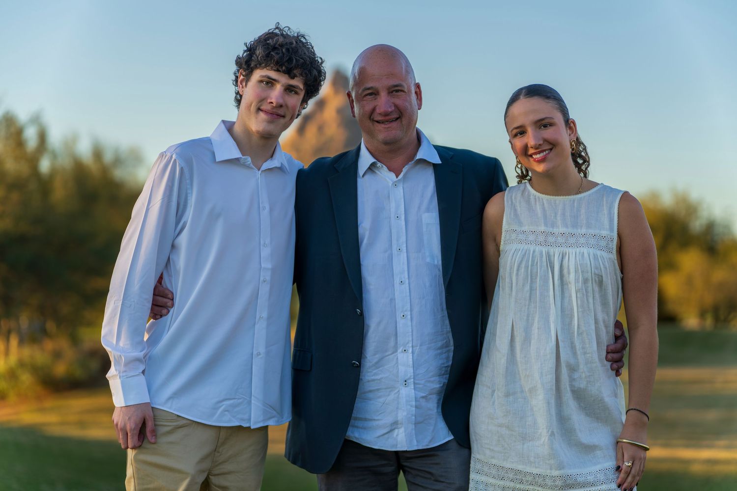 Family members posed together in coordinated outfits during evening photo session.