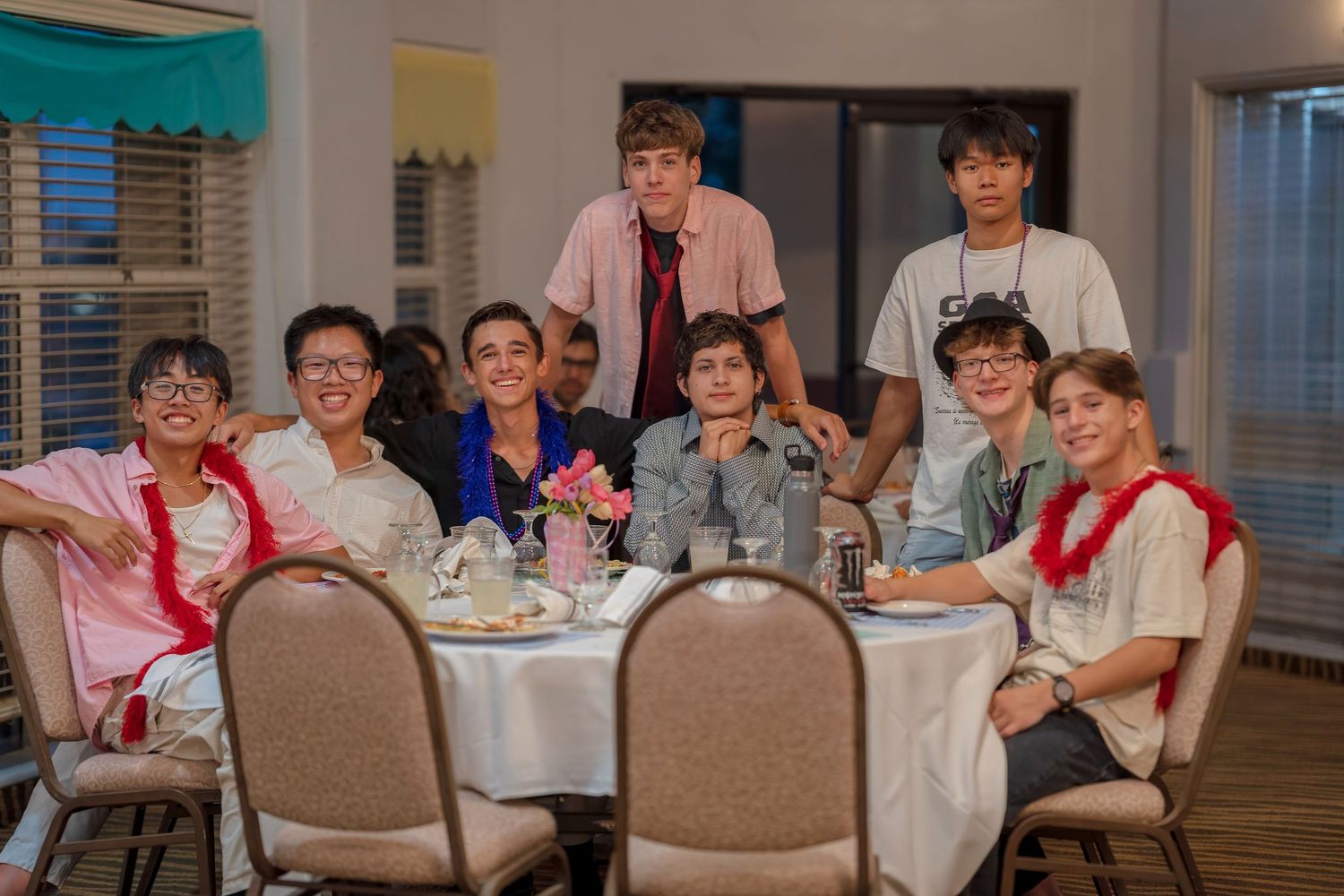 A group seated around a white-clothed table at a formal dinner gathering.