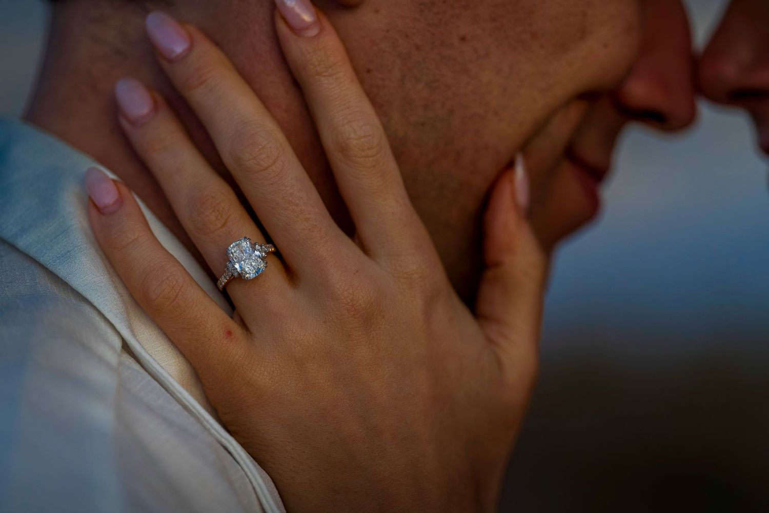 Close-up of hands with a sparkling engagement ring during a romantic moment.
