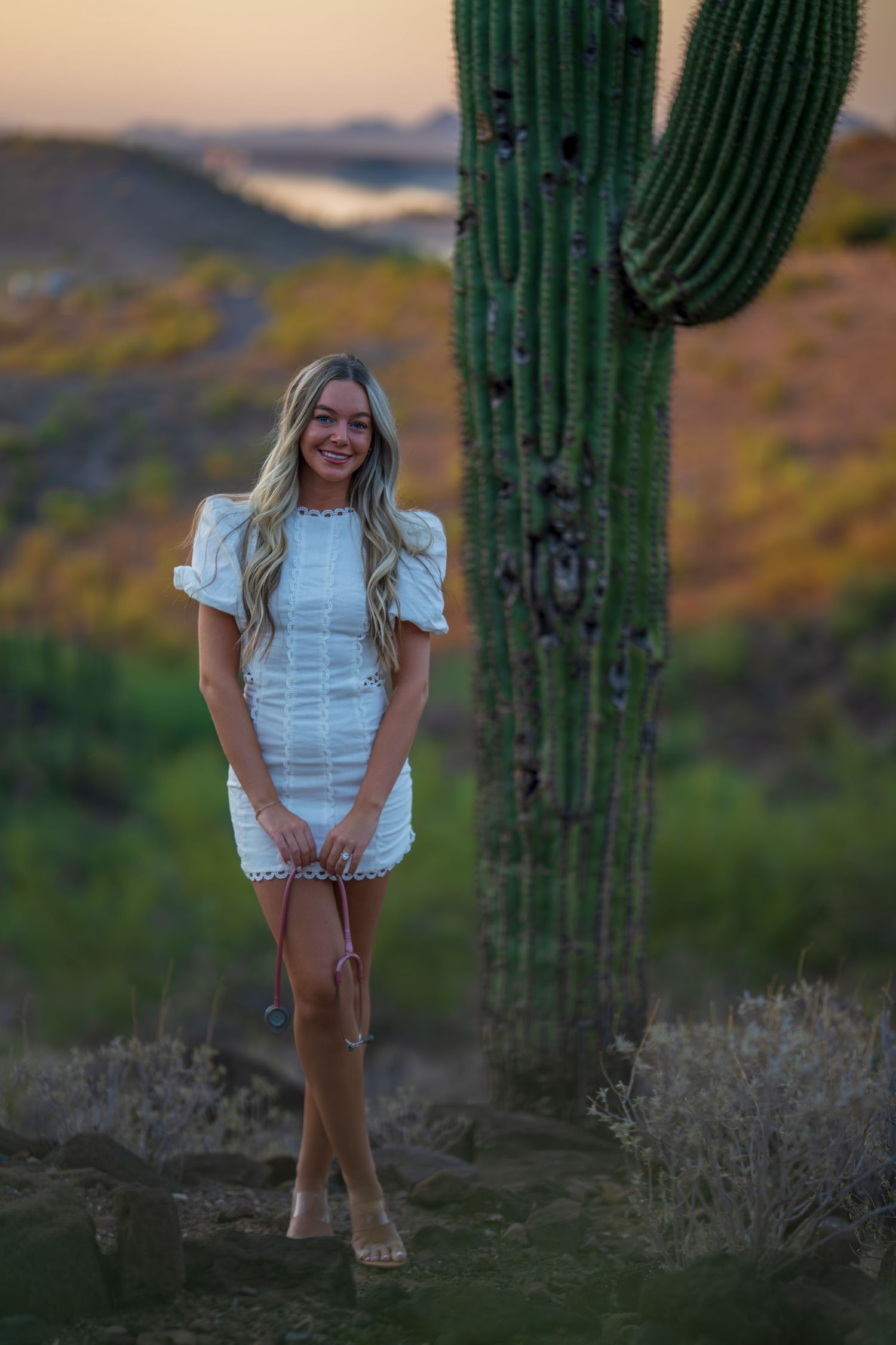 White mini dress photographed against dramatic desert sunset with towering saguaro cactus.