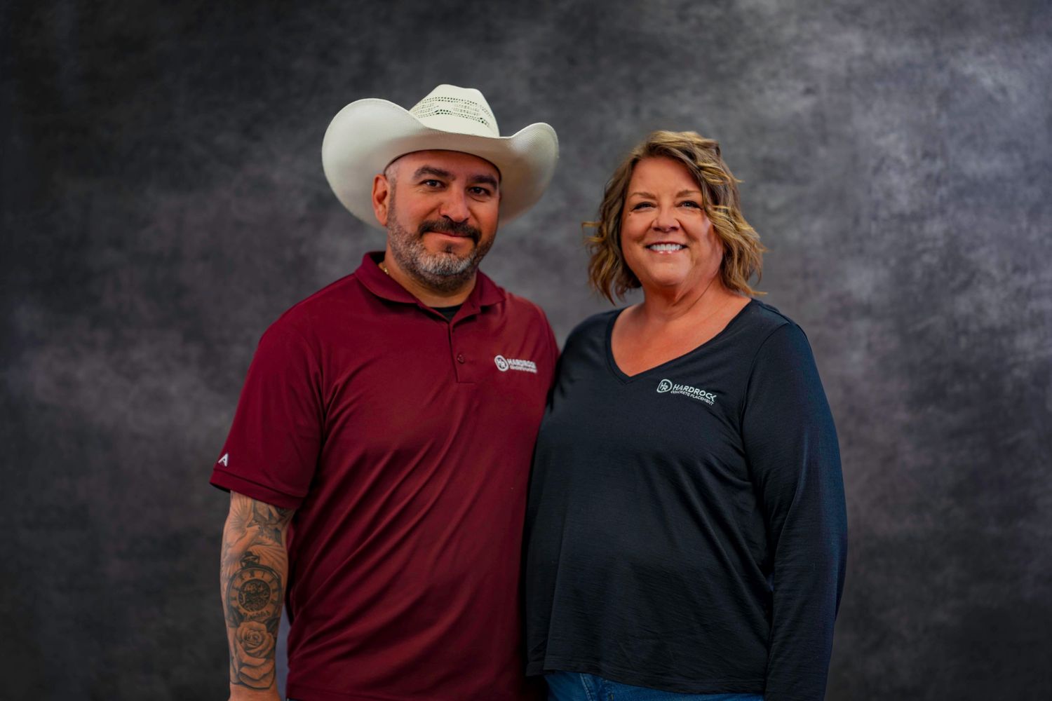 Team members pose together wearing casual business attire against studio backdrop.