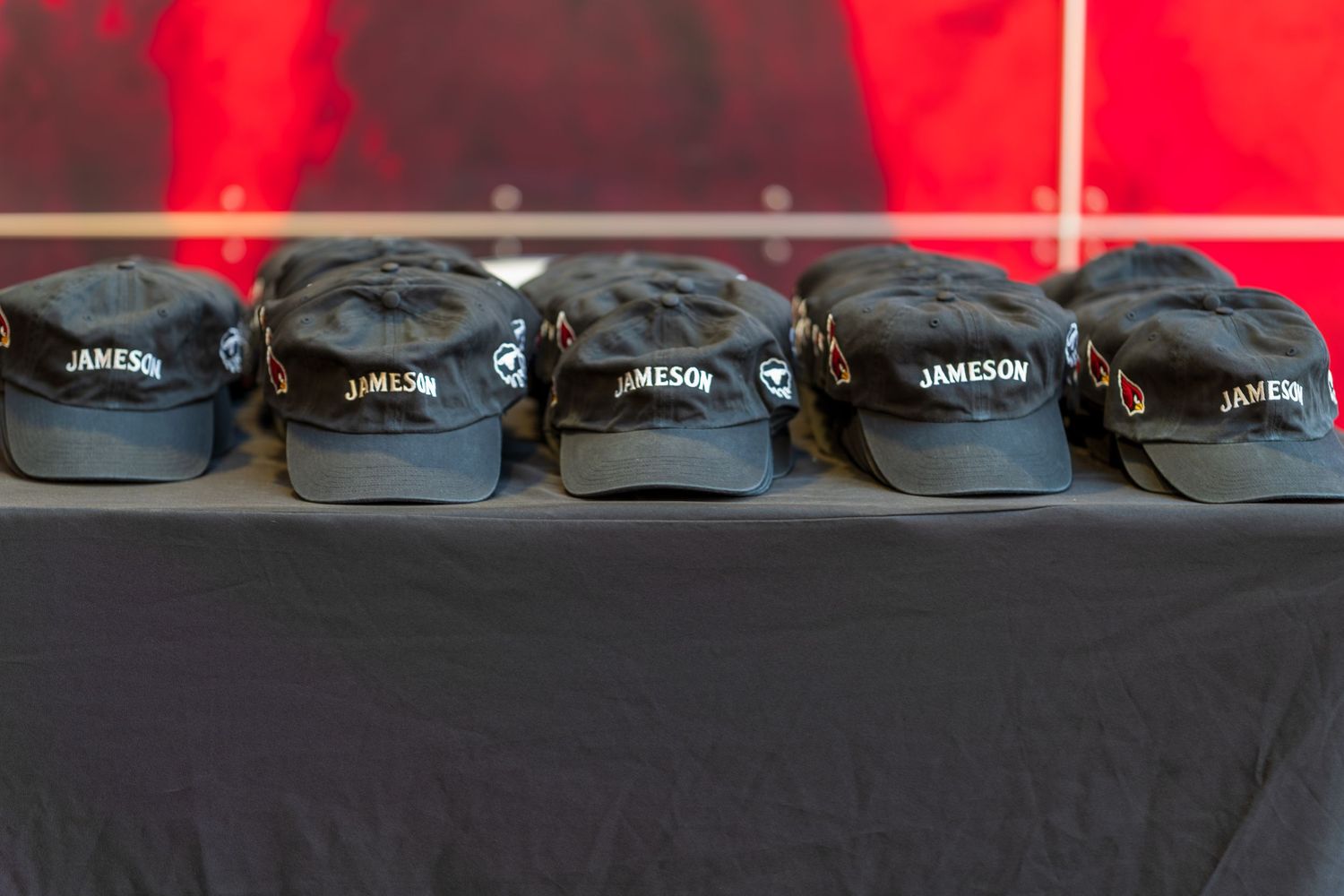 Row of black baseball caps displayed on a shelf with white text branding.