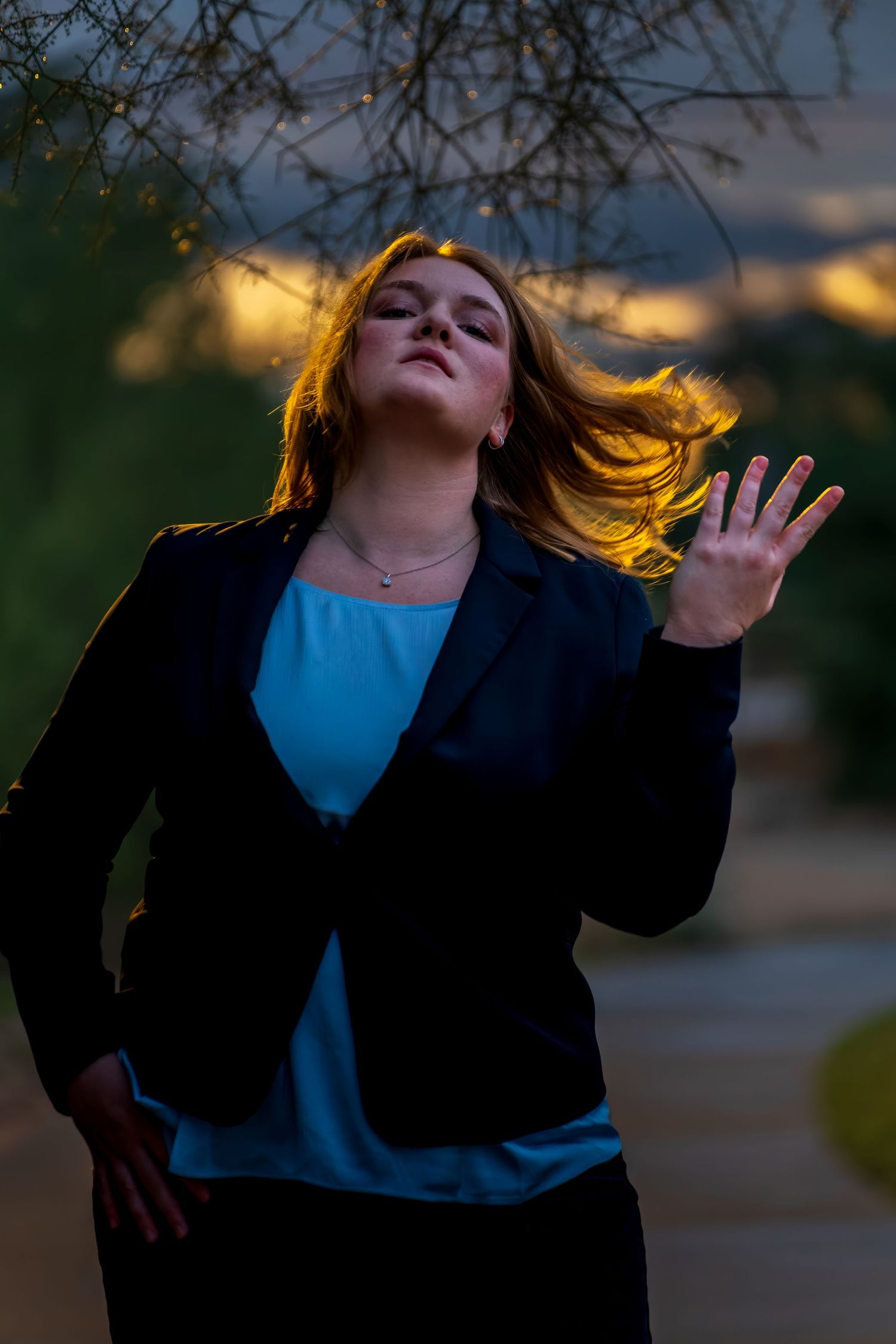 Expressive outdoor portrait with dramatic lighting and flowing movement at sunset.