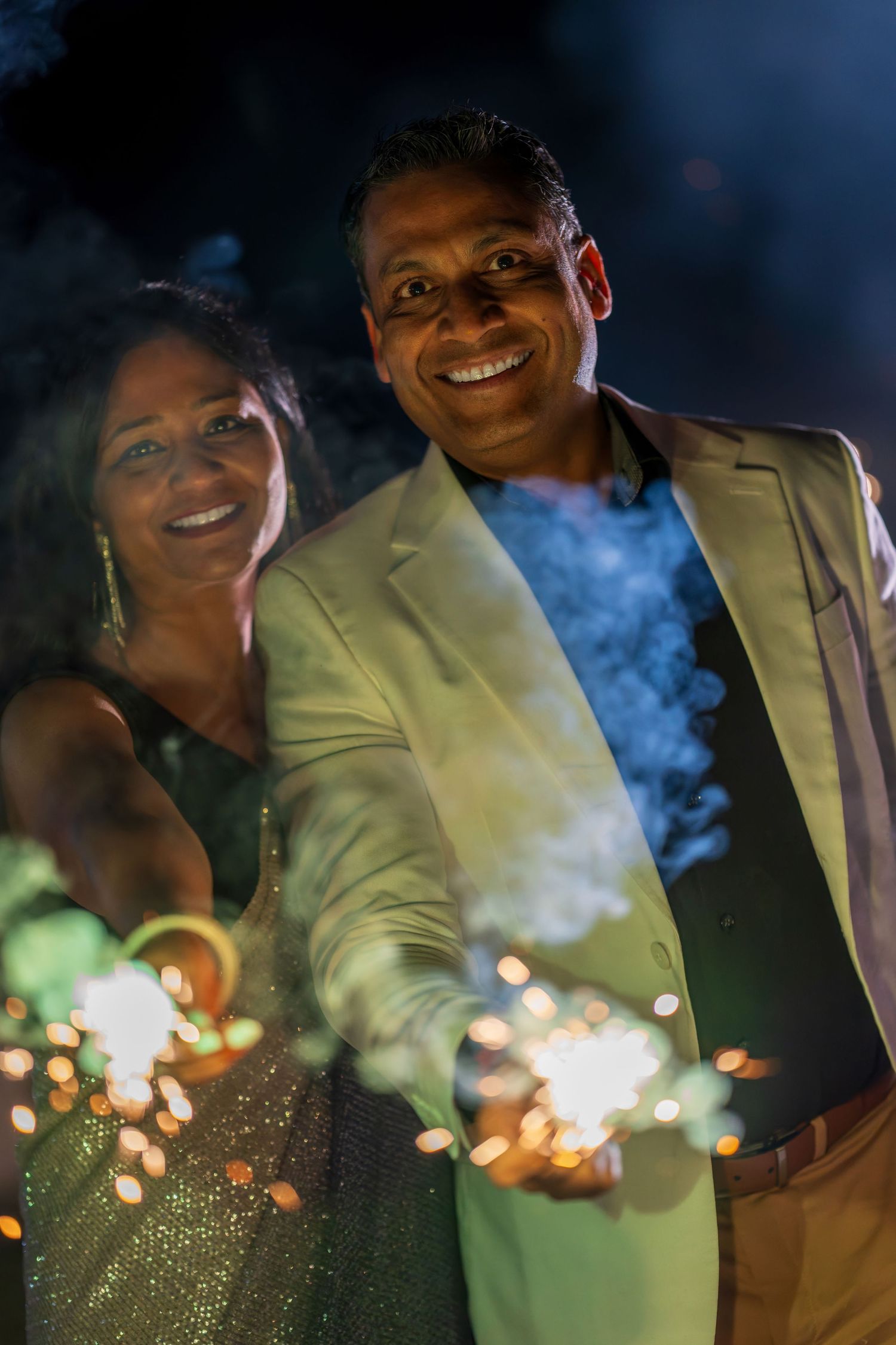 A couple sharing a celebratory moment with sparklers in the evening.