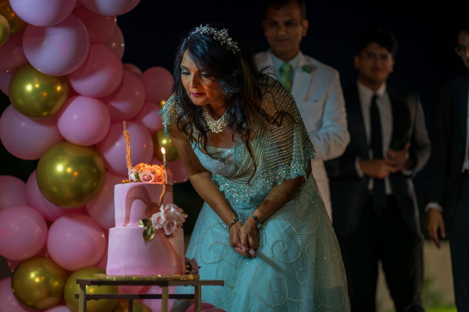 A celebration setup with pink balloon arrangements and ambient lighting.