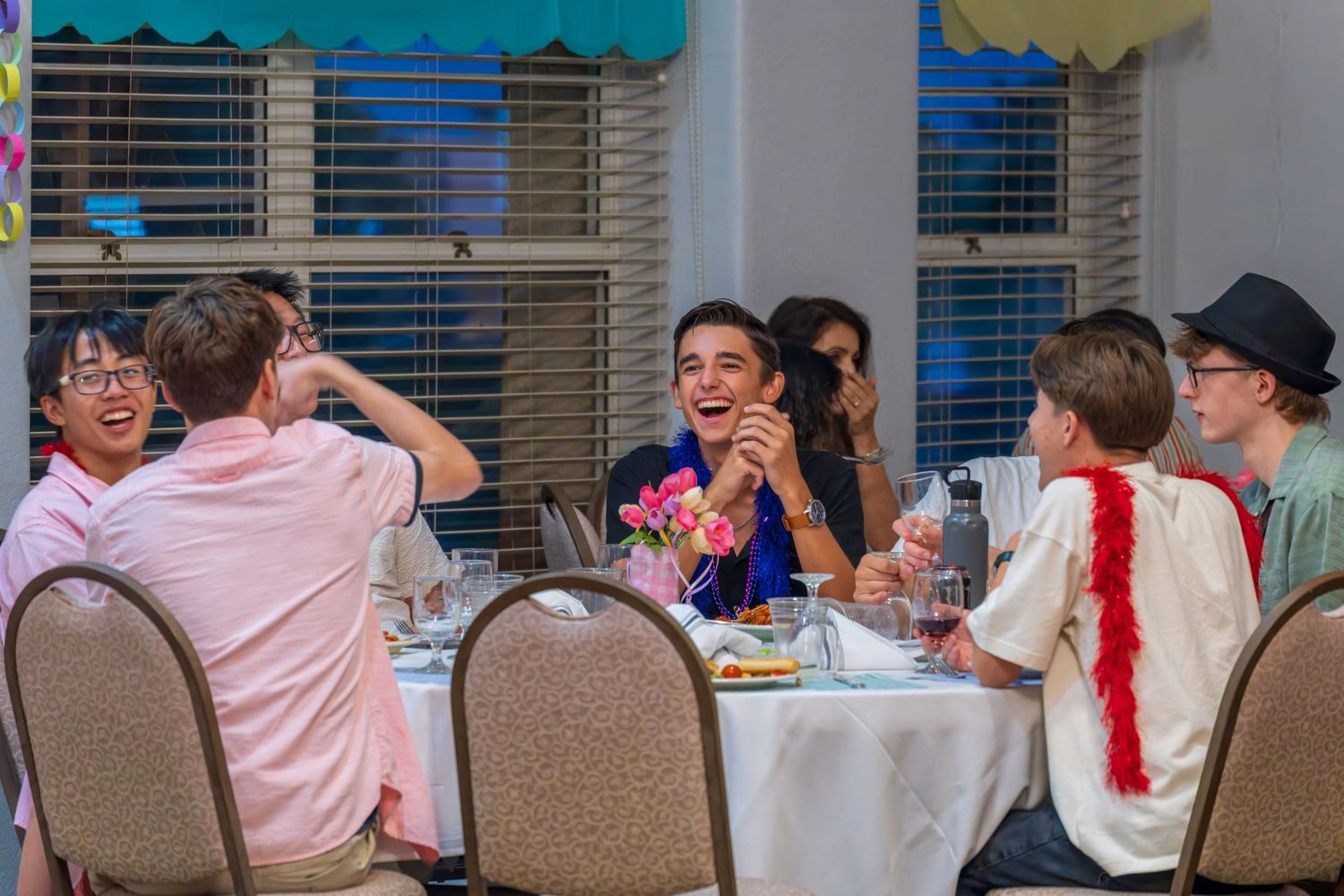 Long table setup at a party with pink decorations and balloons.