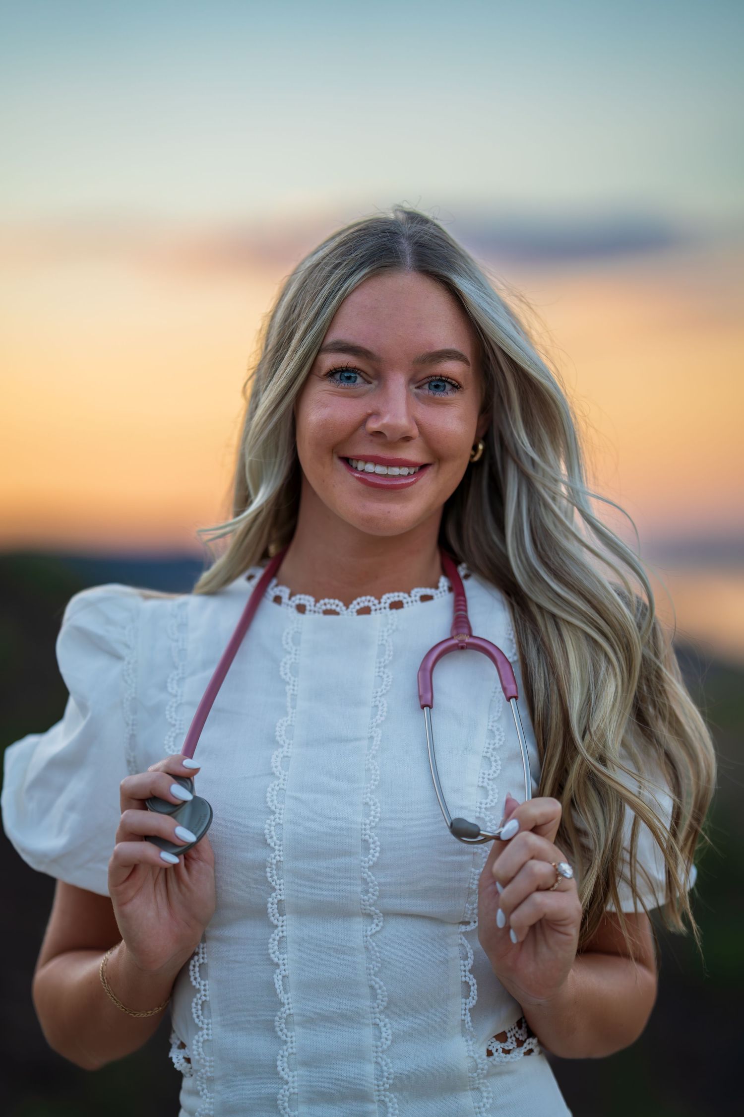 Close-up portrait with stethoscope against desert sunset background.