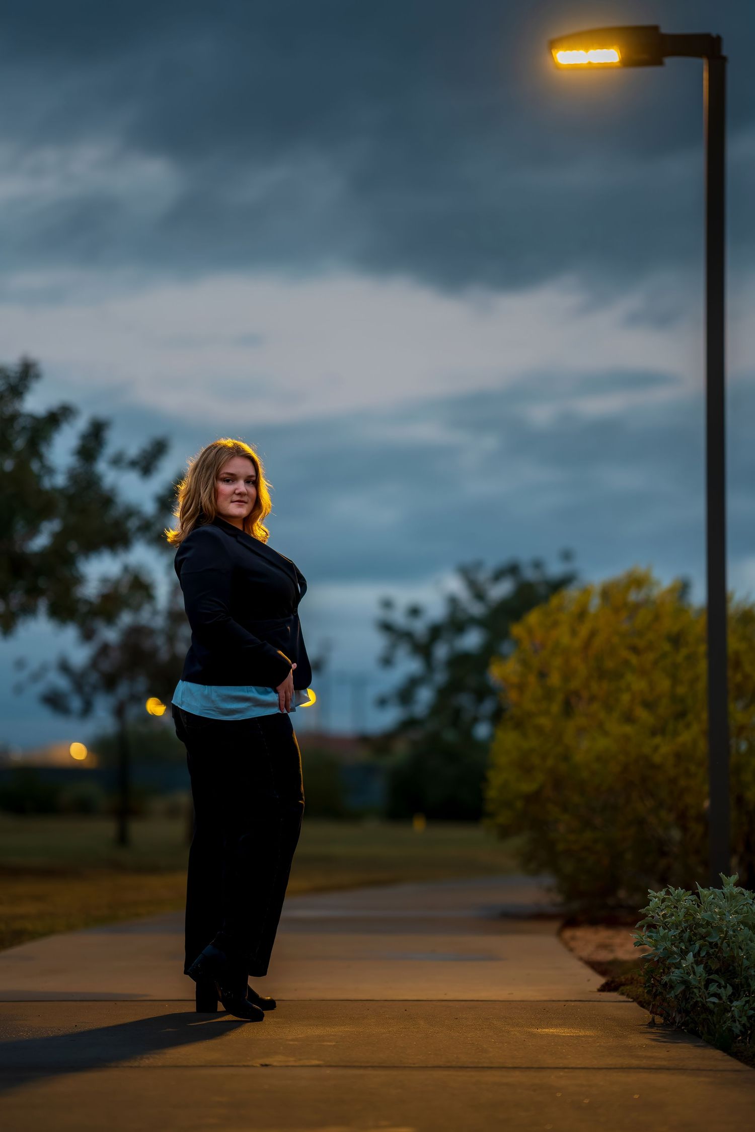 Evening photoshoot under street lights with moody sky backdrop.