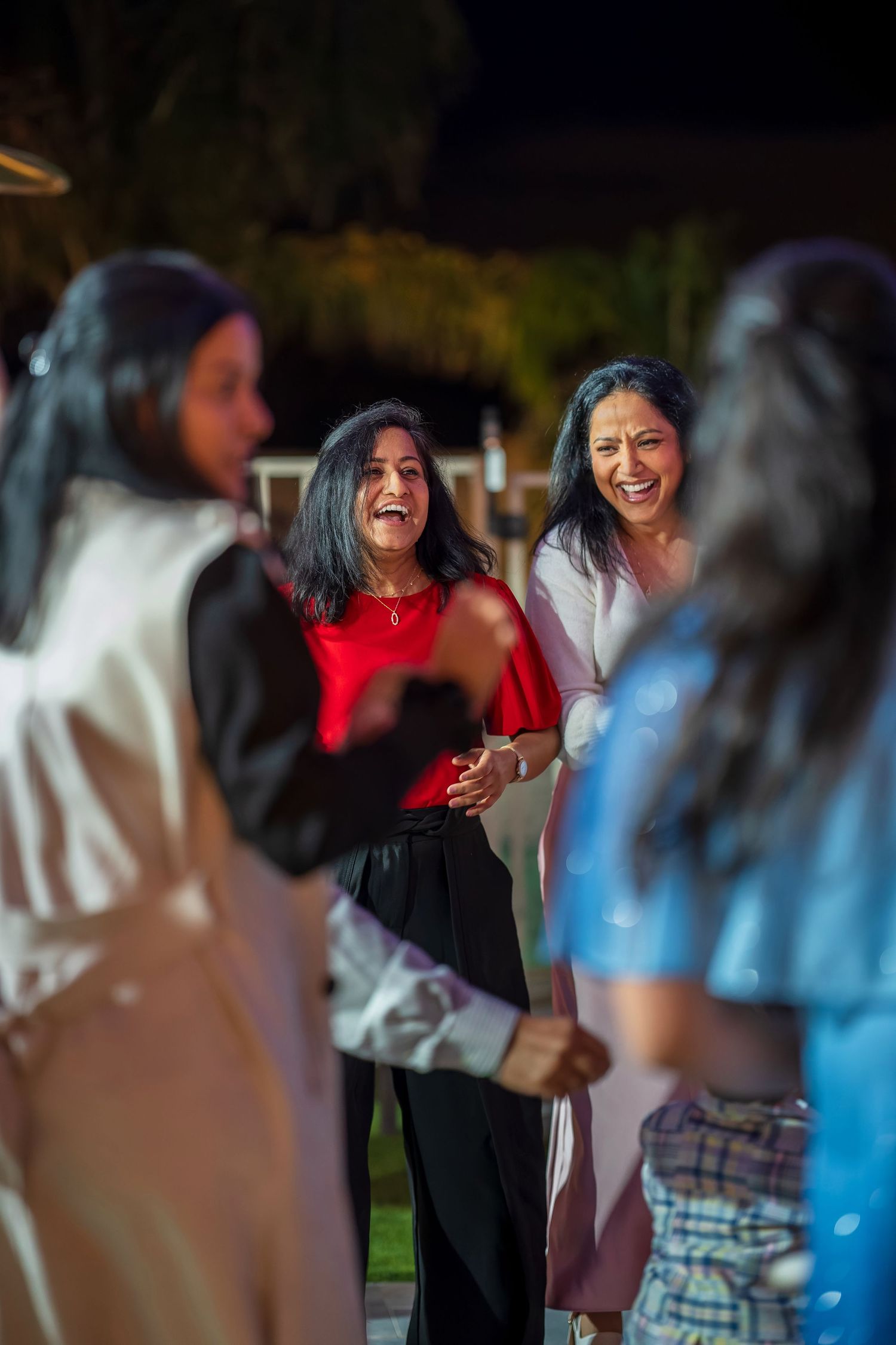 Energetic party scene with people dancing and laughing together outdoors.