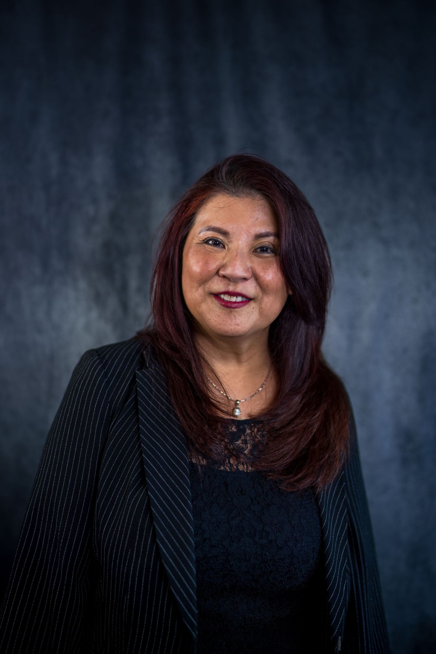Professional headshot series showing warm smile against dark background wearing black blazer.