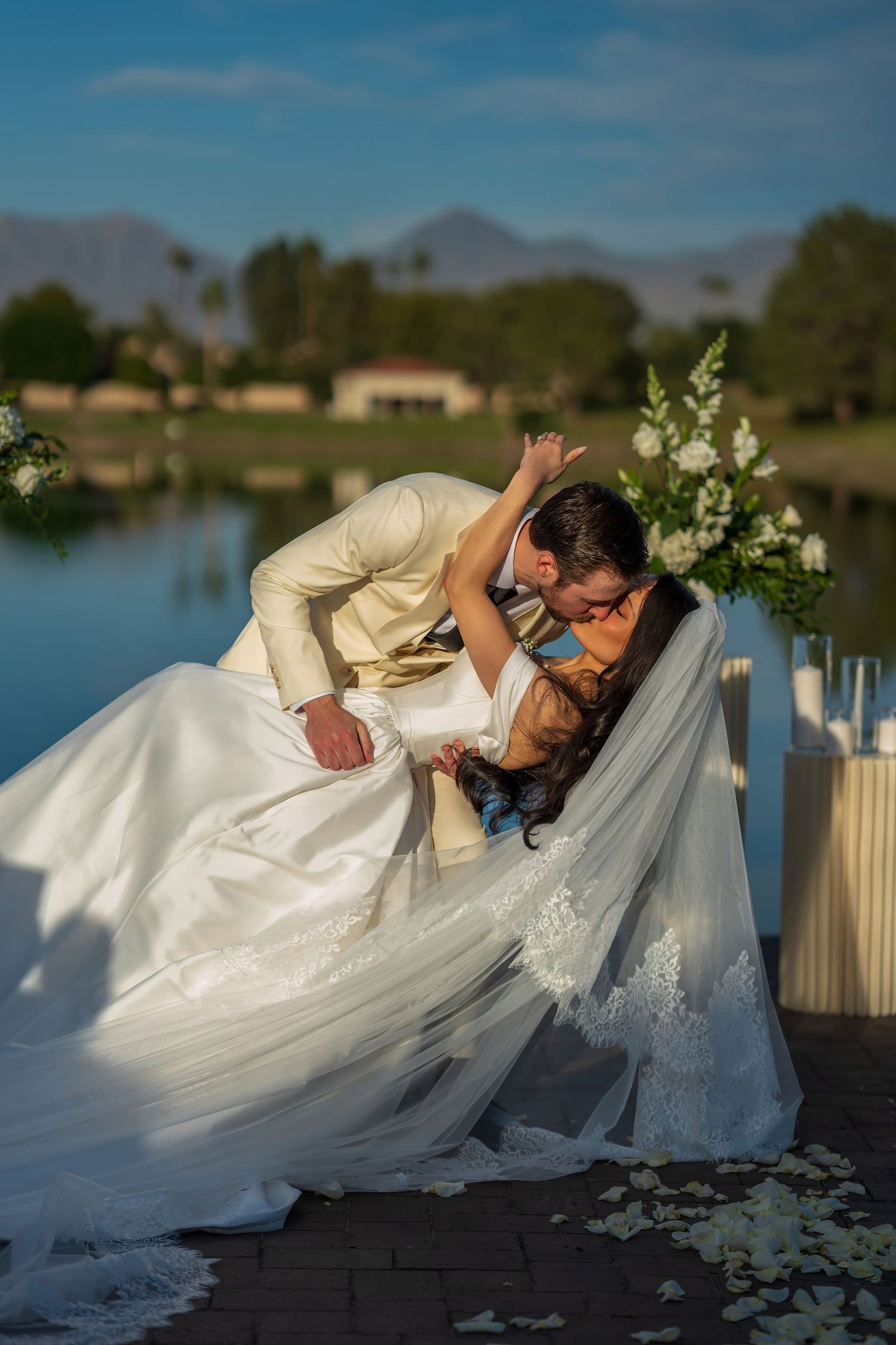 A romantic wedding couple sharing an intimate dip pose during their lakeside photo session.