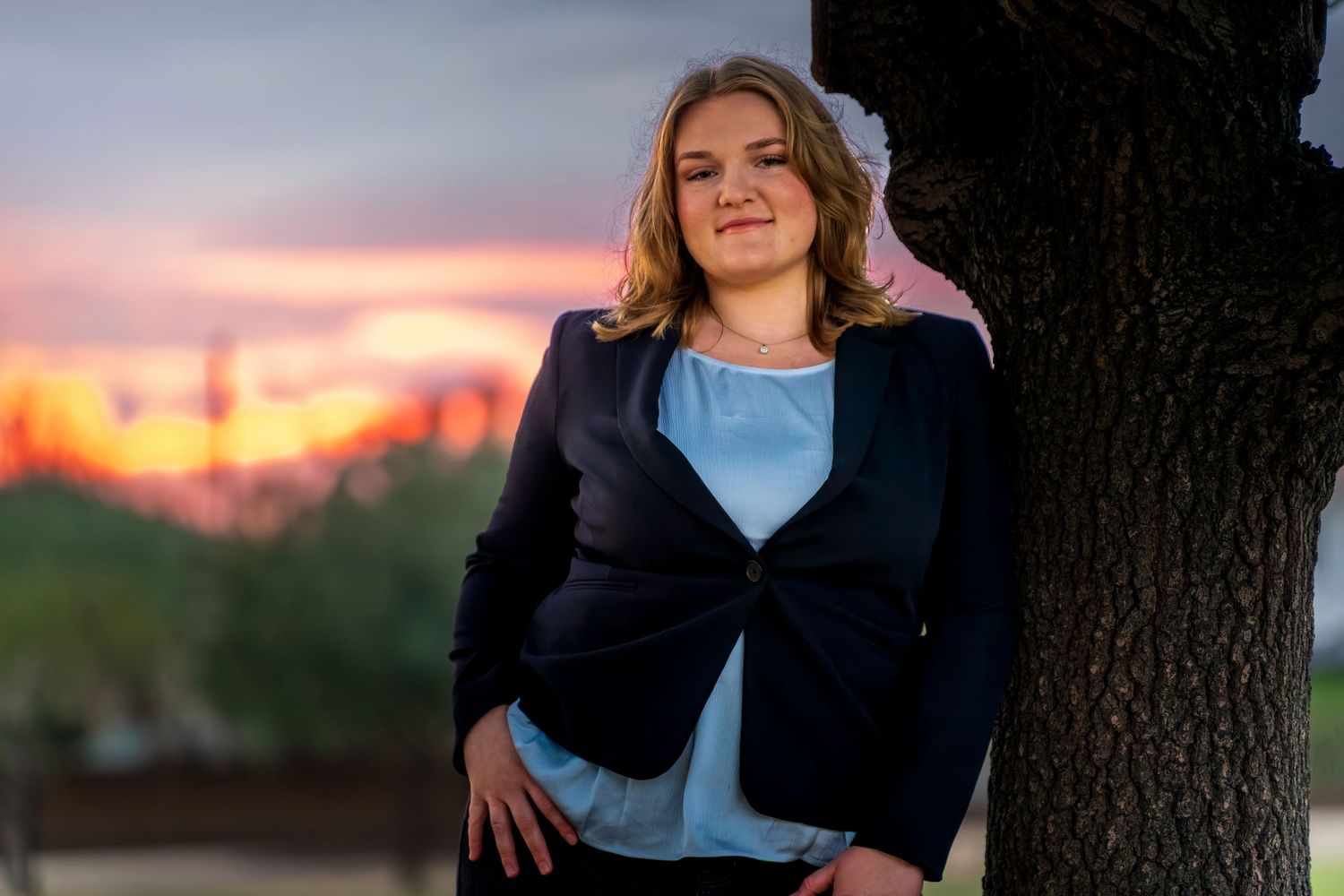 Sunset portrait session with tree silhouette and pink sky.
