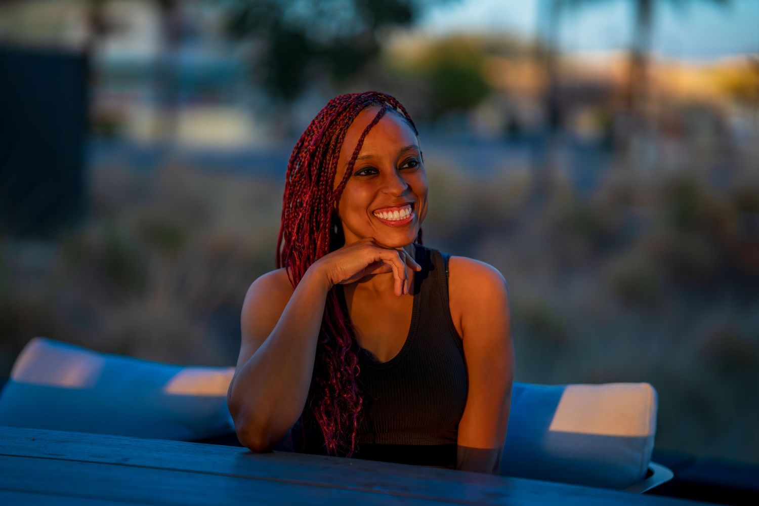 Casual outdoor portrait session with urban background at dusk.