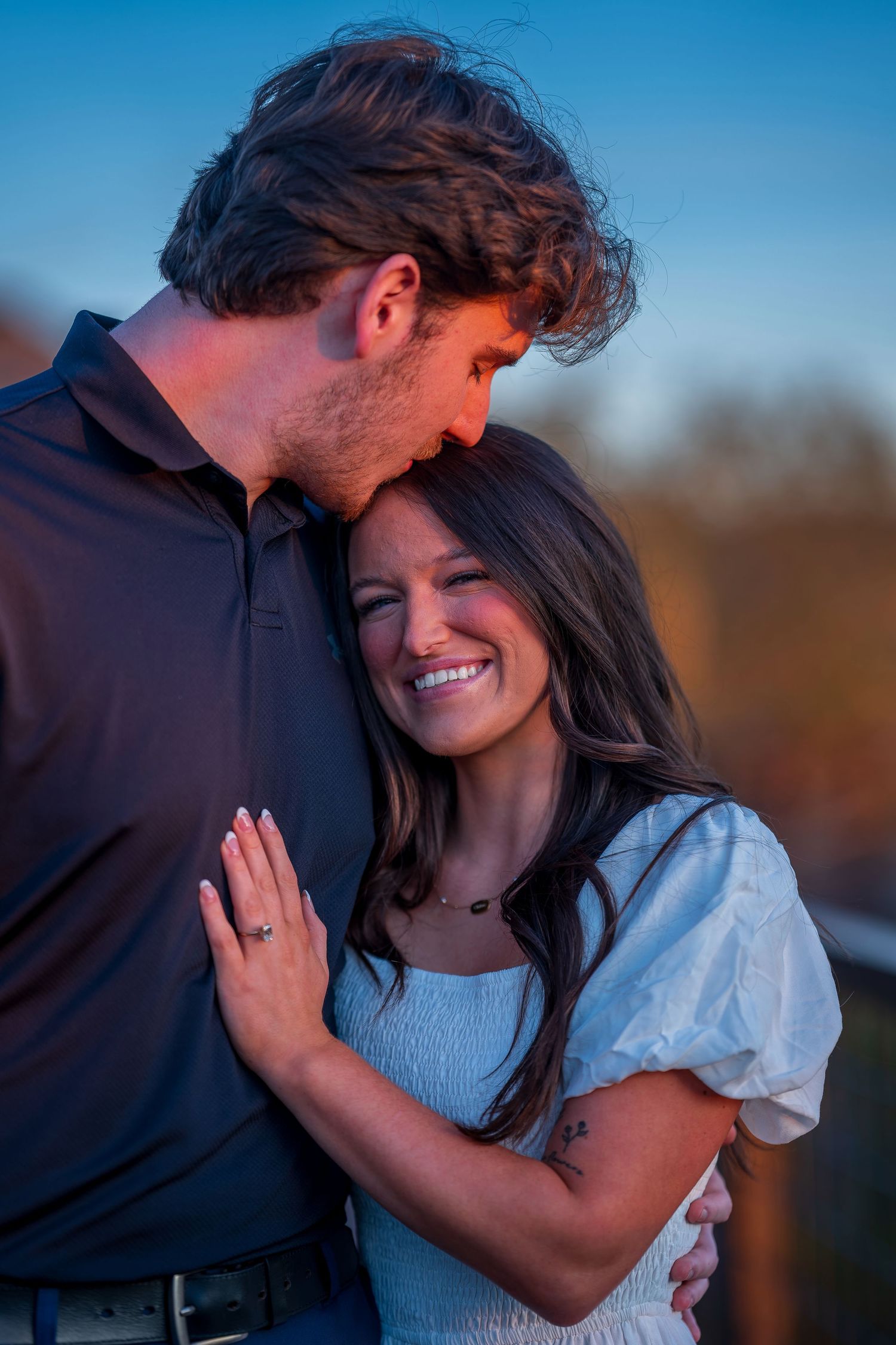 Intimate moment between a couple during their sunset engagement photos.