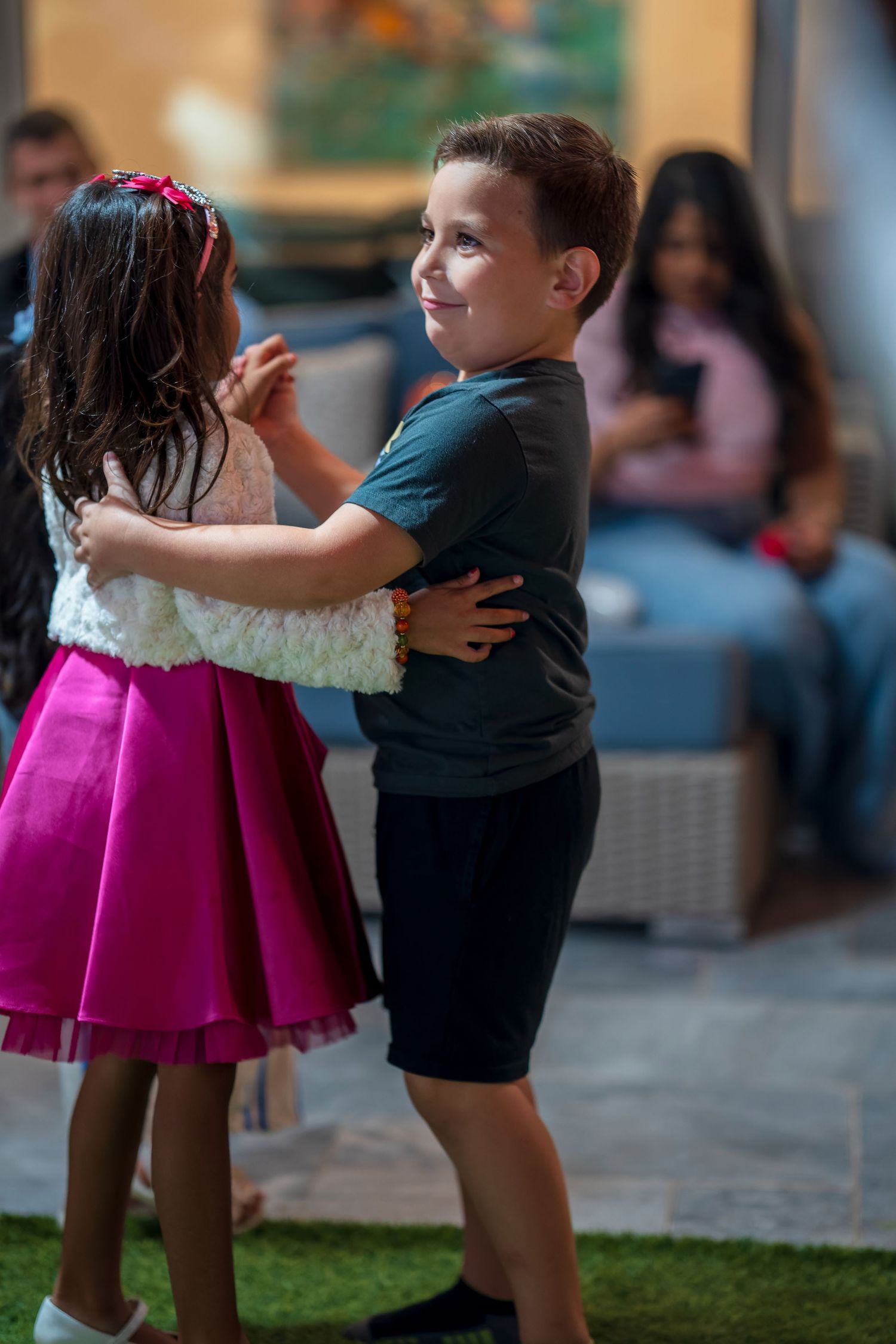 Two young dancers share a sweet moment during a celebration.