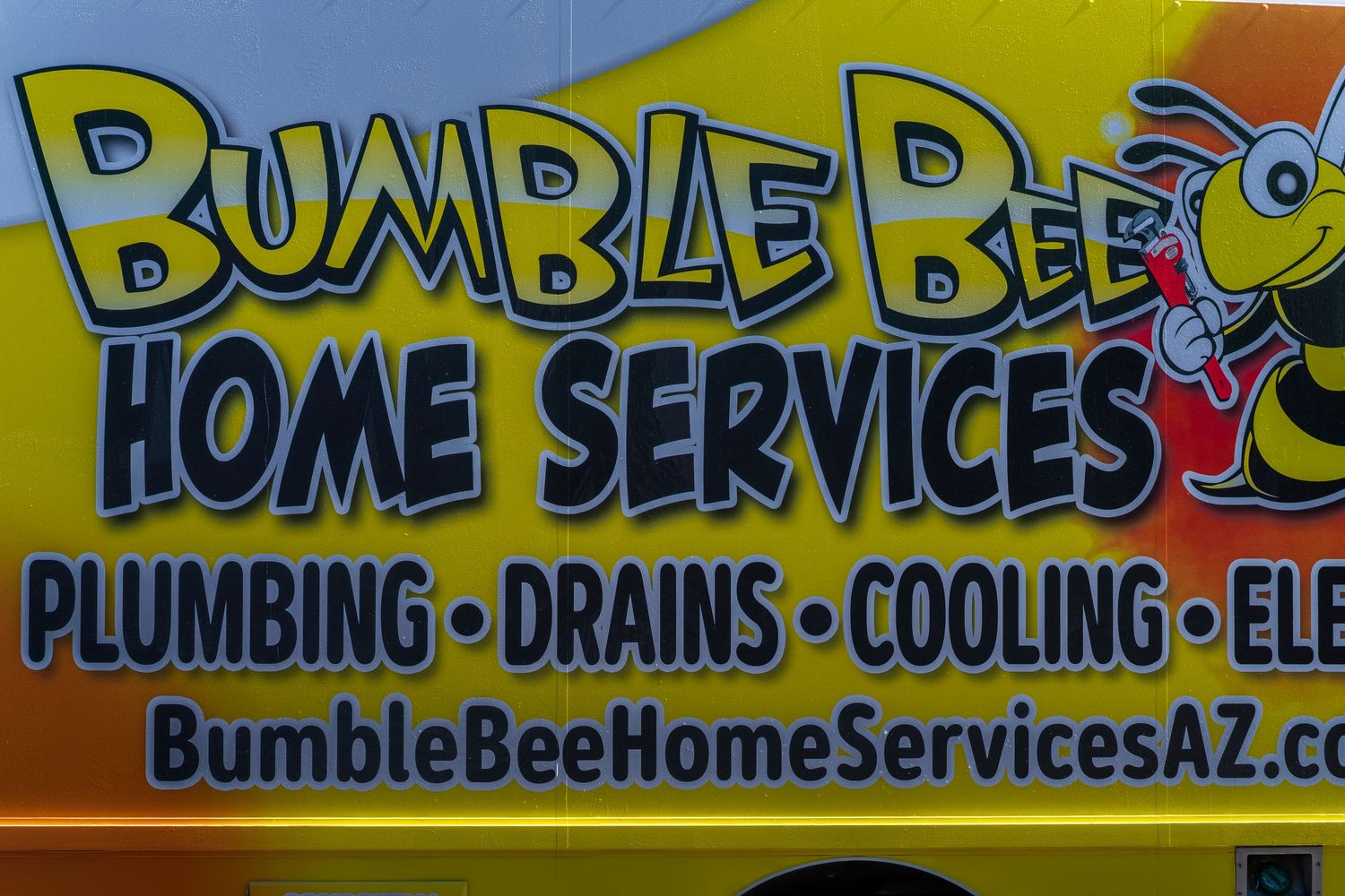 Yellow and black company branding on service vehicle showing plumbing and HVAC services.