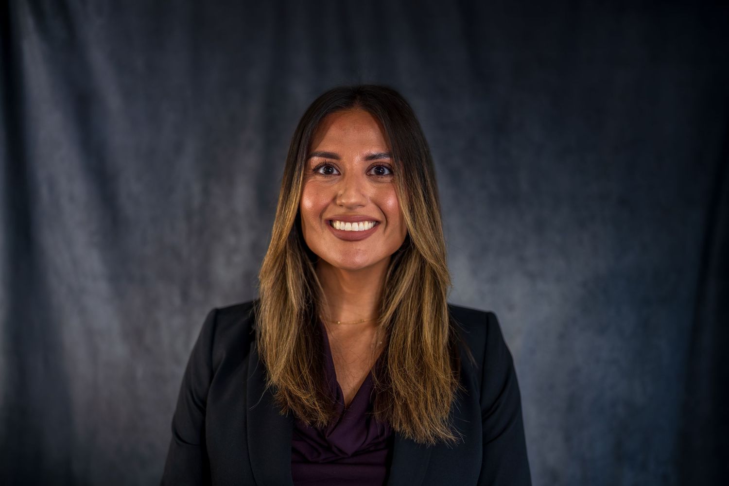 Studio headshot series with natural smile wearing professional attire.