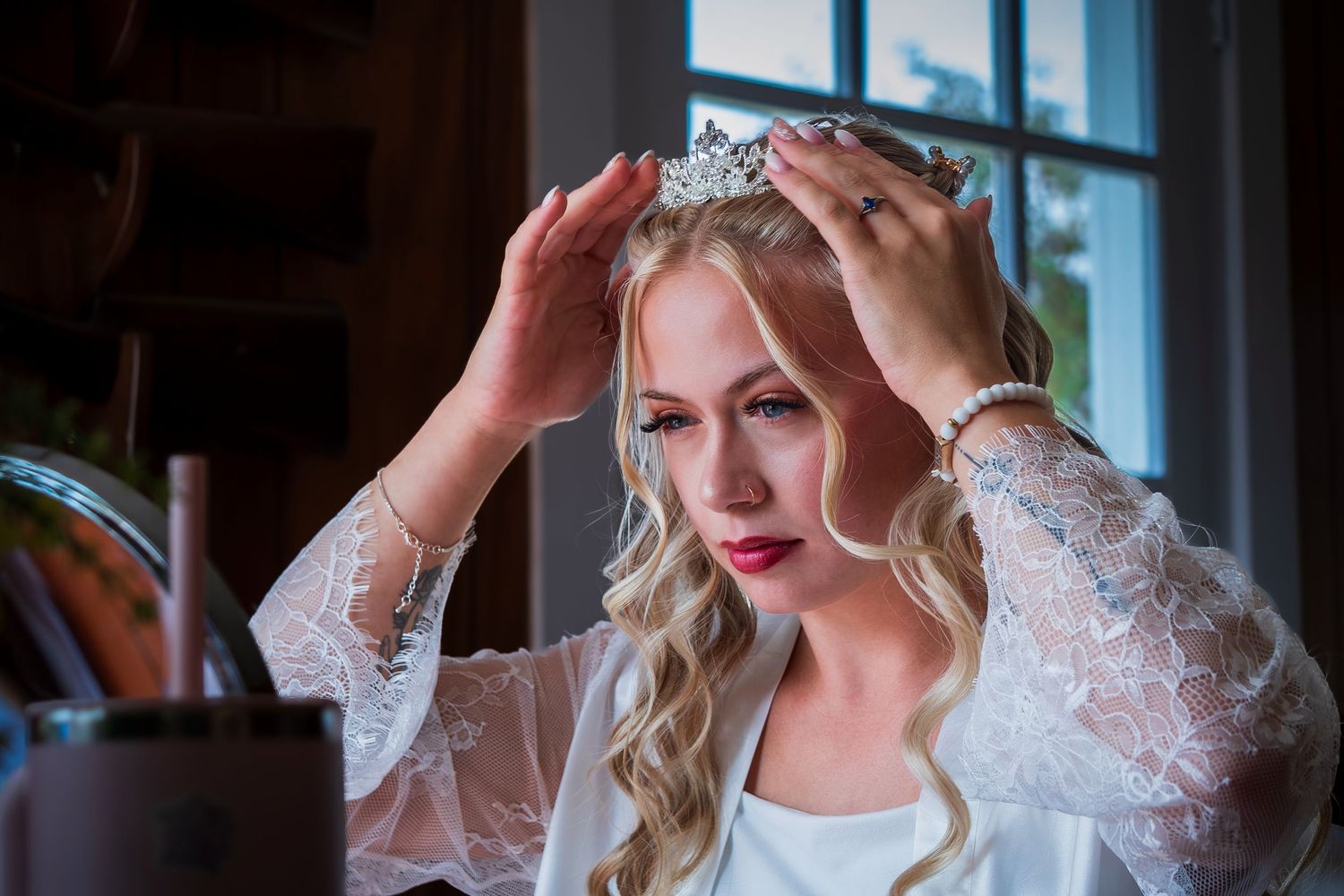 Bride having her veil and tiara adjusted while getting ready for the ceremony.