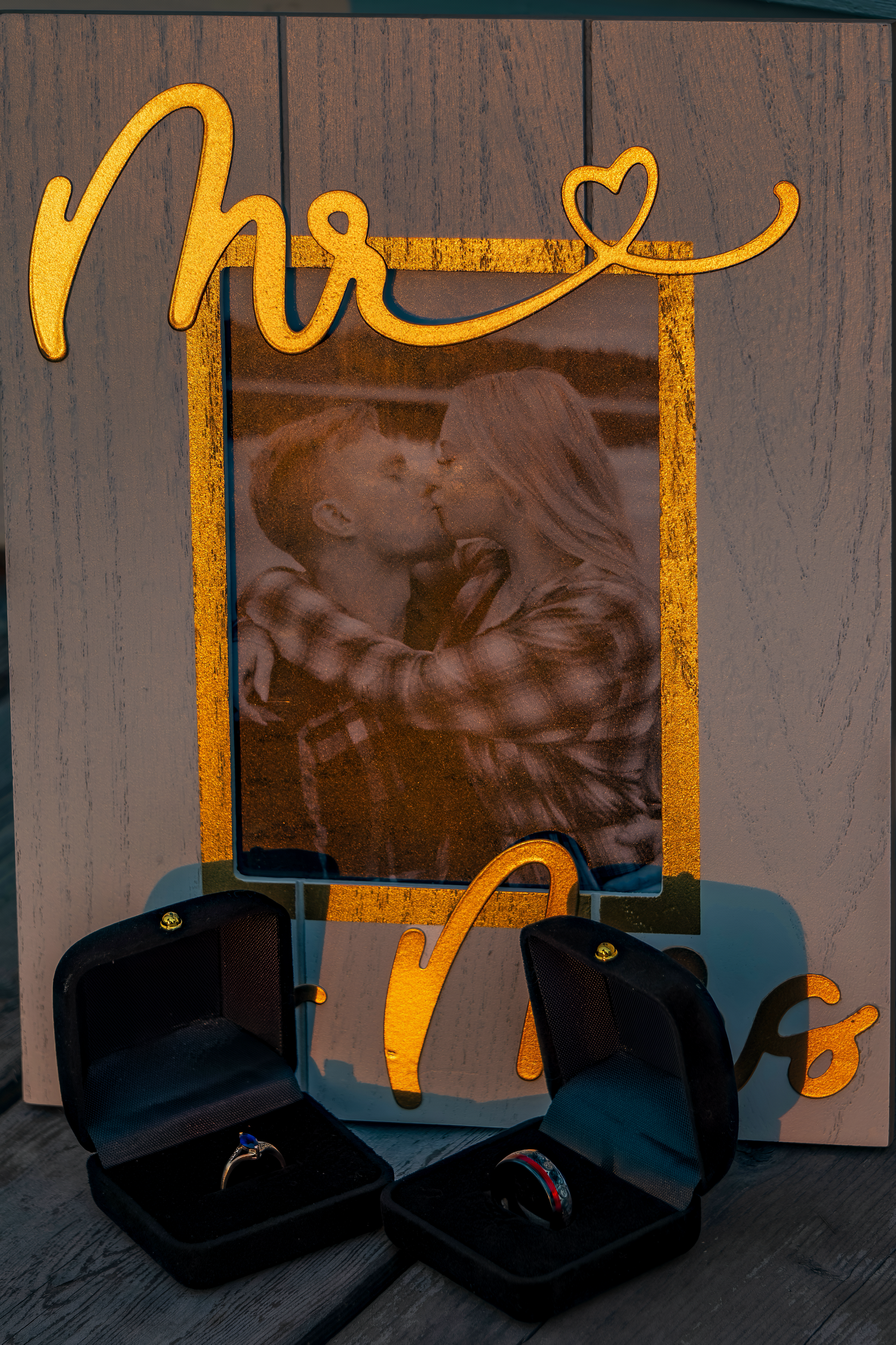 Silhouetted photo display with gold lettering and decorative elements on wooden surface.