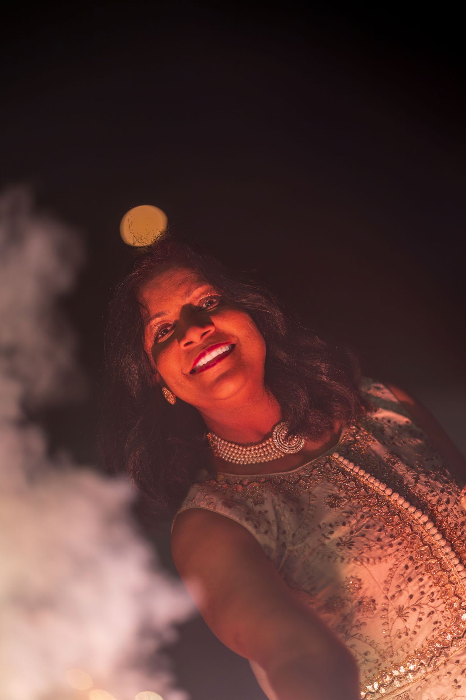 Dramatic red lighting creates atmospheric portrait during celebration.