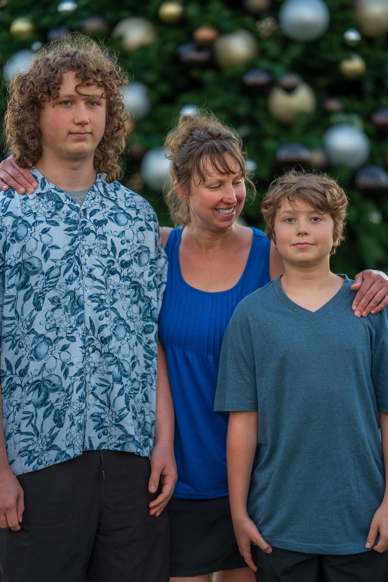 Close-up portrait of family members wearing coordinating blue and gray outfits.