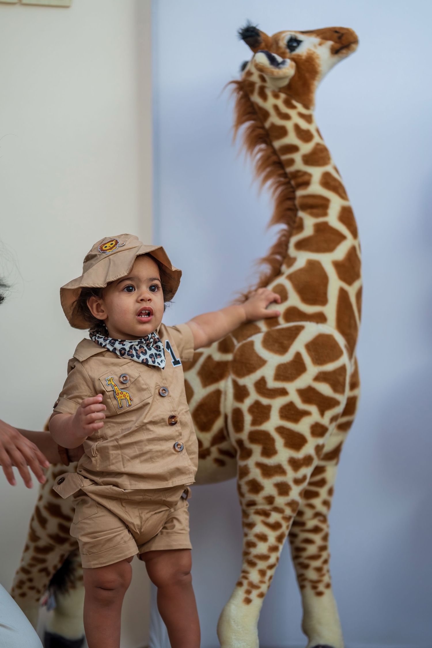 A safari-themed birthday setup featuring a large decorative giraffe and themed party decor.