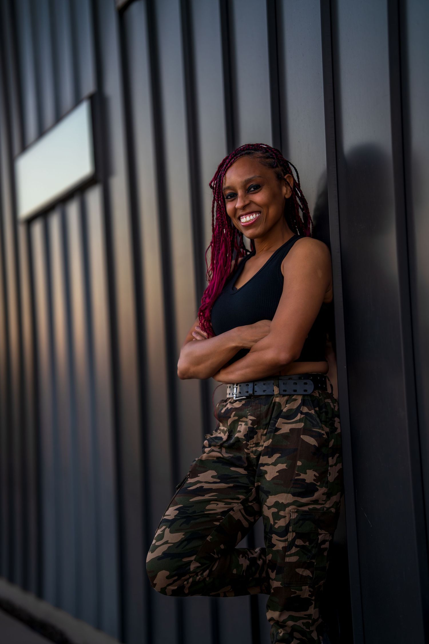 Relaxed portrait against modern architectural backdrop with evening lighting.