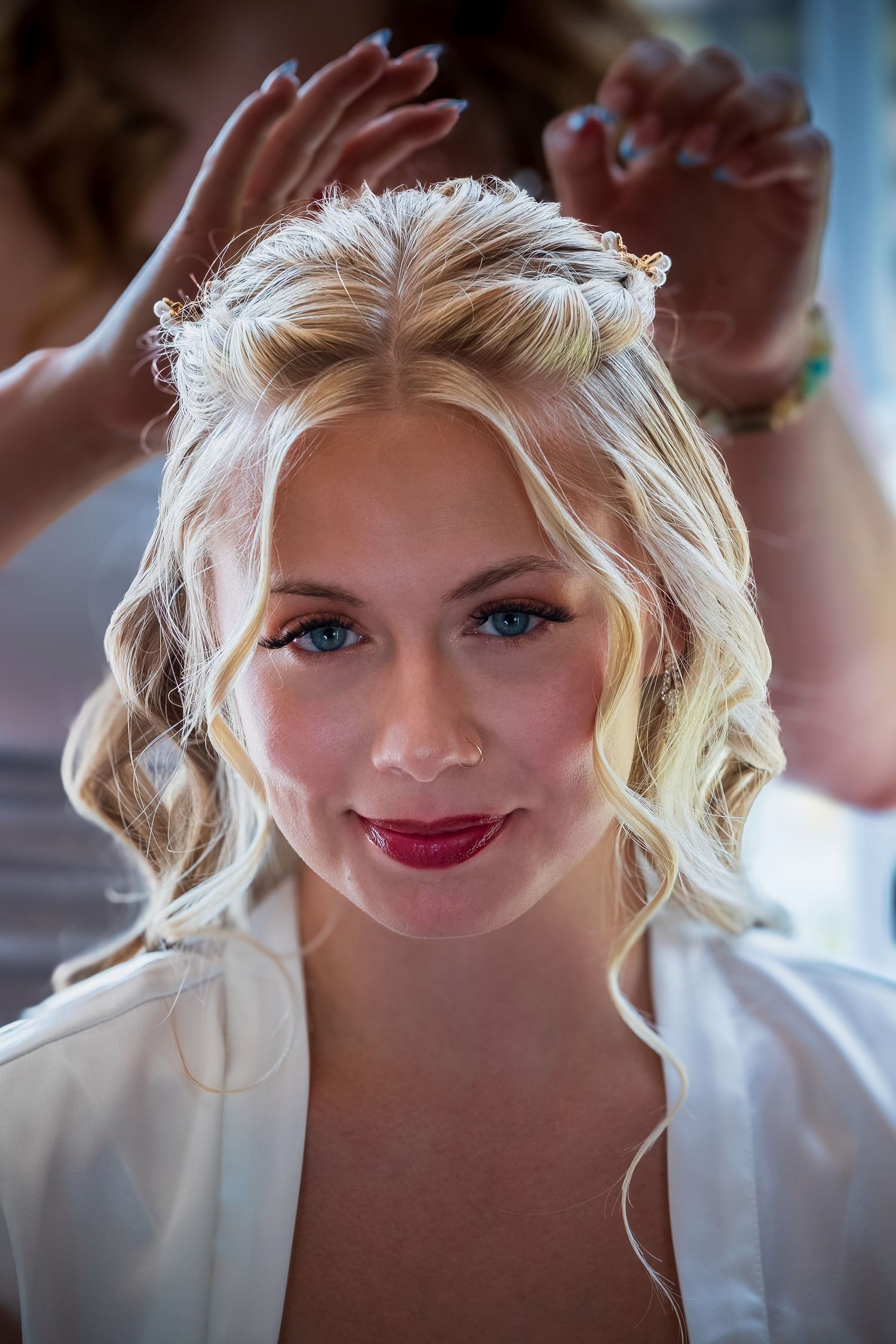 Close-up beauty shots of a bride getting ready on her wedding day showing bright makeup and blonde hair.