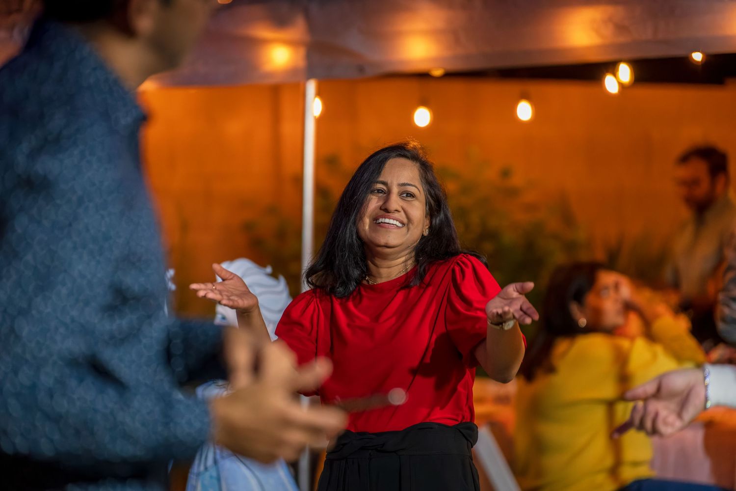 Partygoers enjoying themselves under warm ambient lighting at an evening celebration.