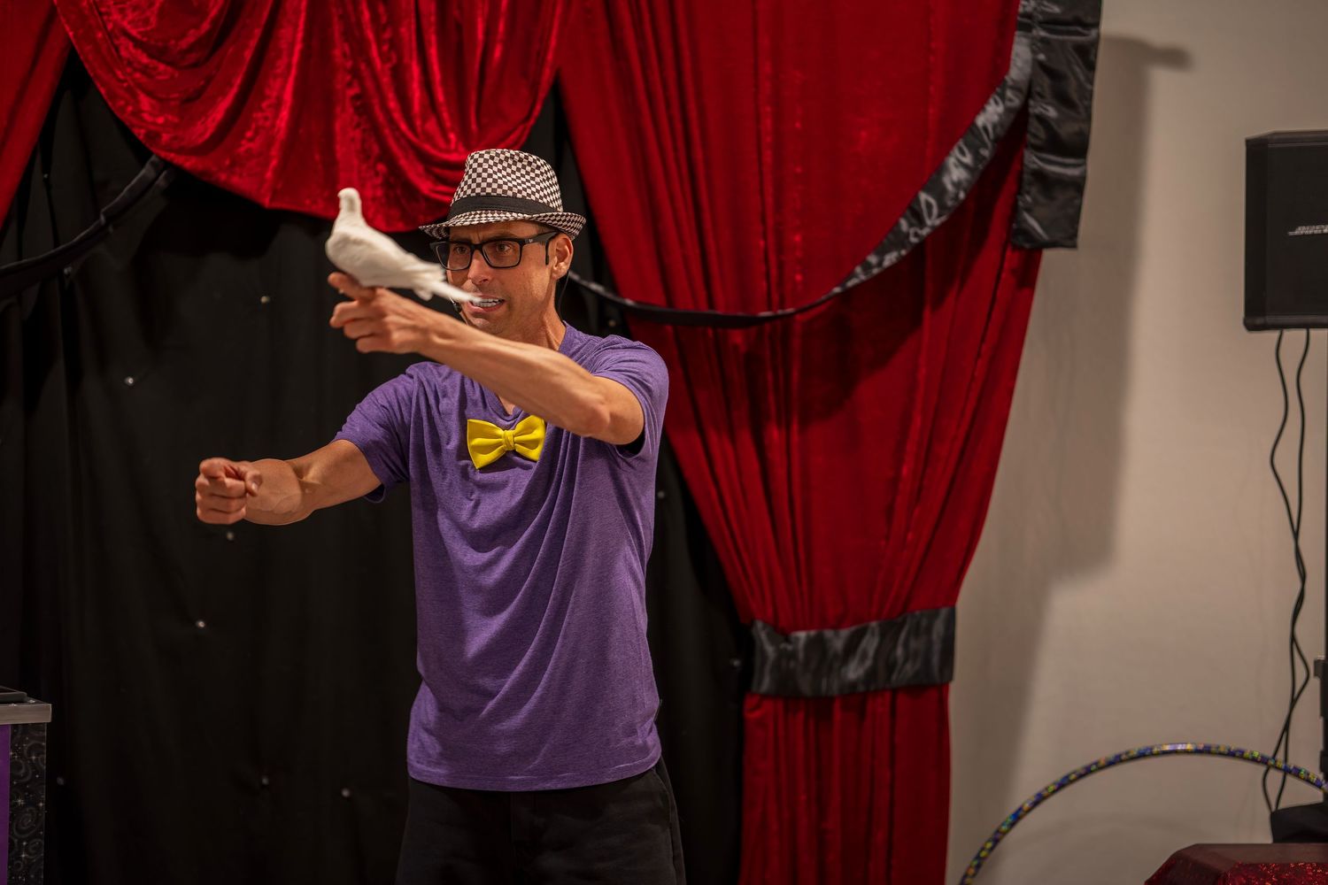 Performers in purple attire presenting magic tricks on stage.